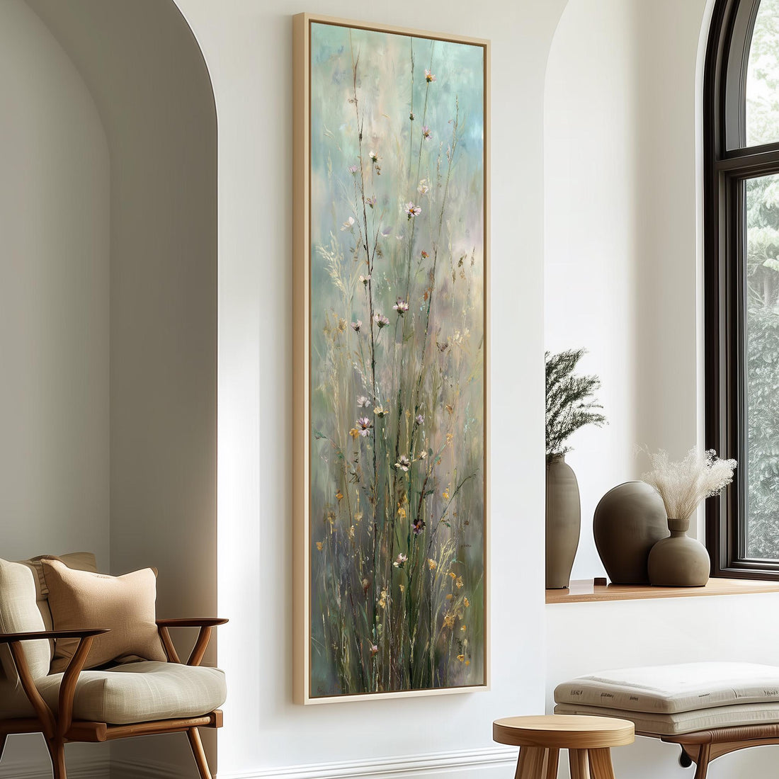 a large painting of tall grasses with flowers hanging on a wall in a room with a wooden chair, a small table, and a window.