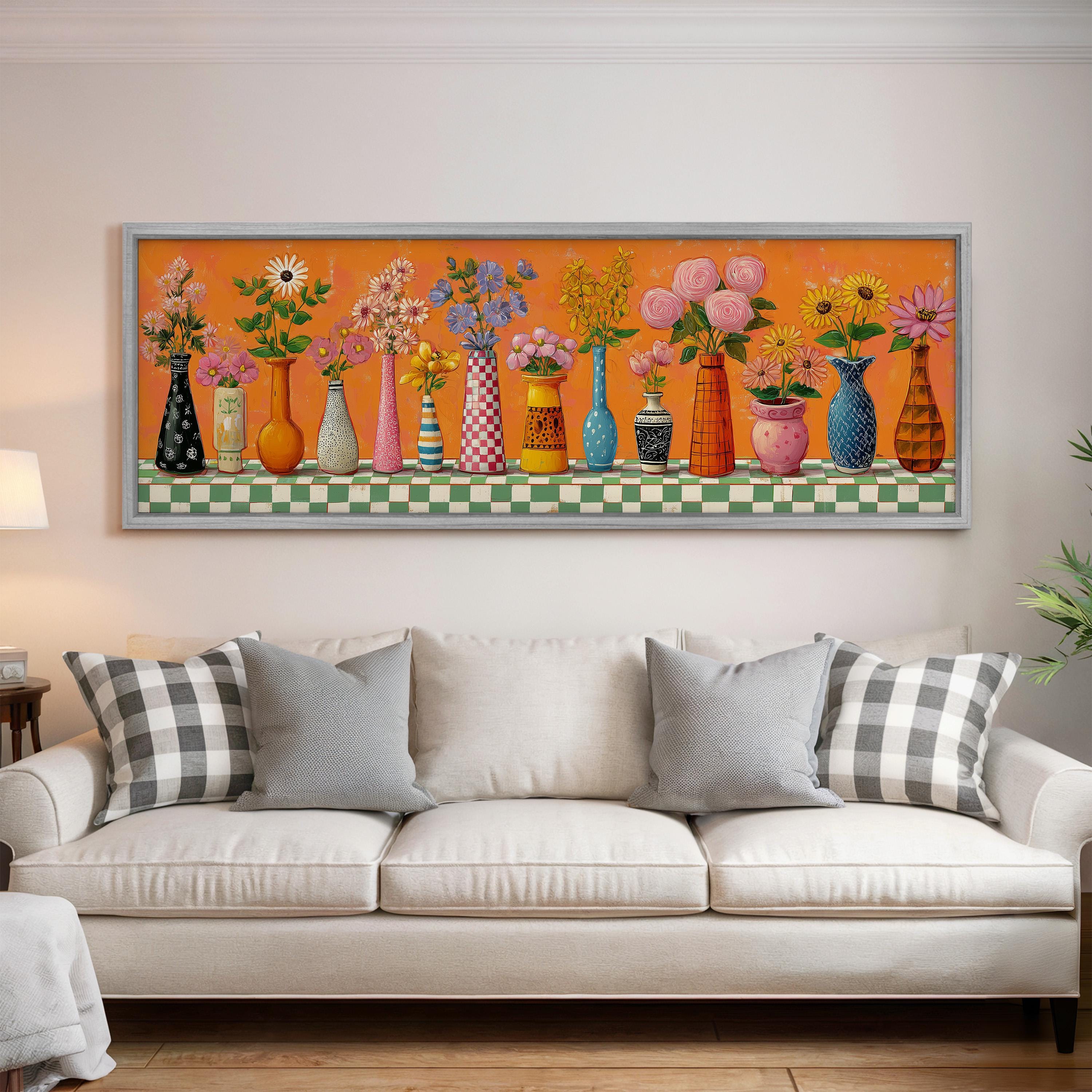 a large, colorful painting of various vases and flowers displayed on a wall above a white couch in a living room setting.