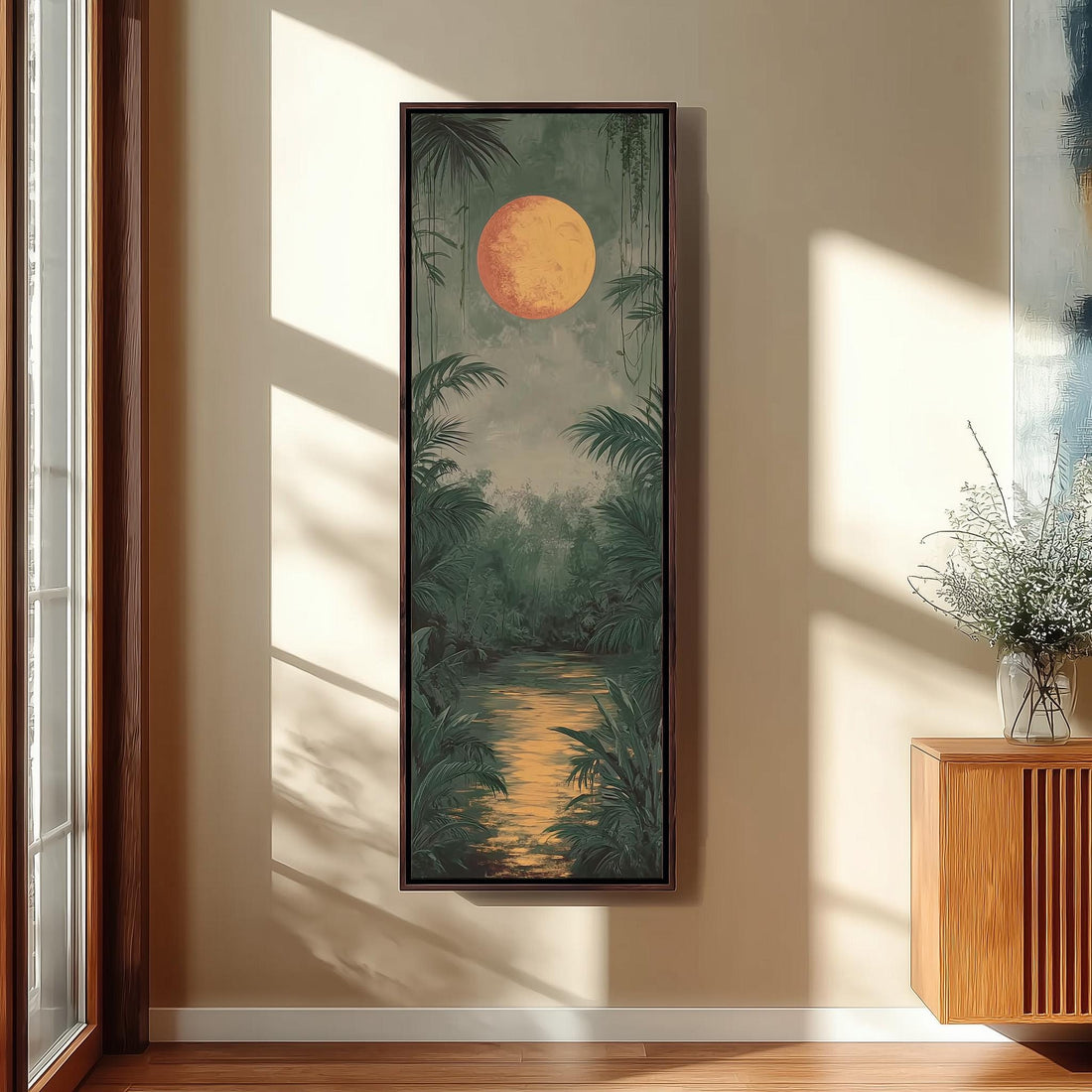 a large framed painting of a tropical landscape with a large orange sun in the sky, surrounded by lush greenery and a winding river.