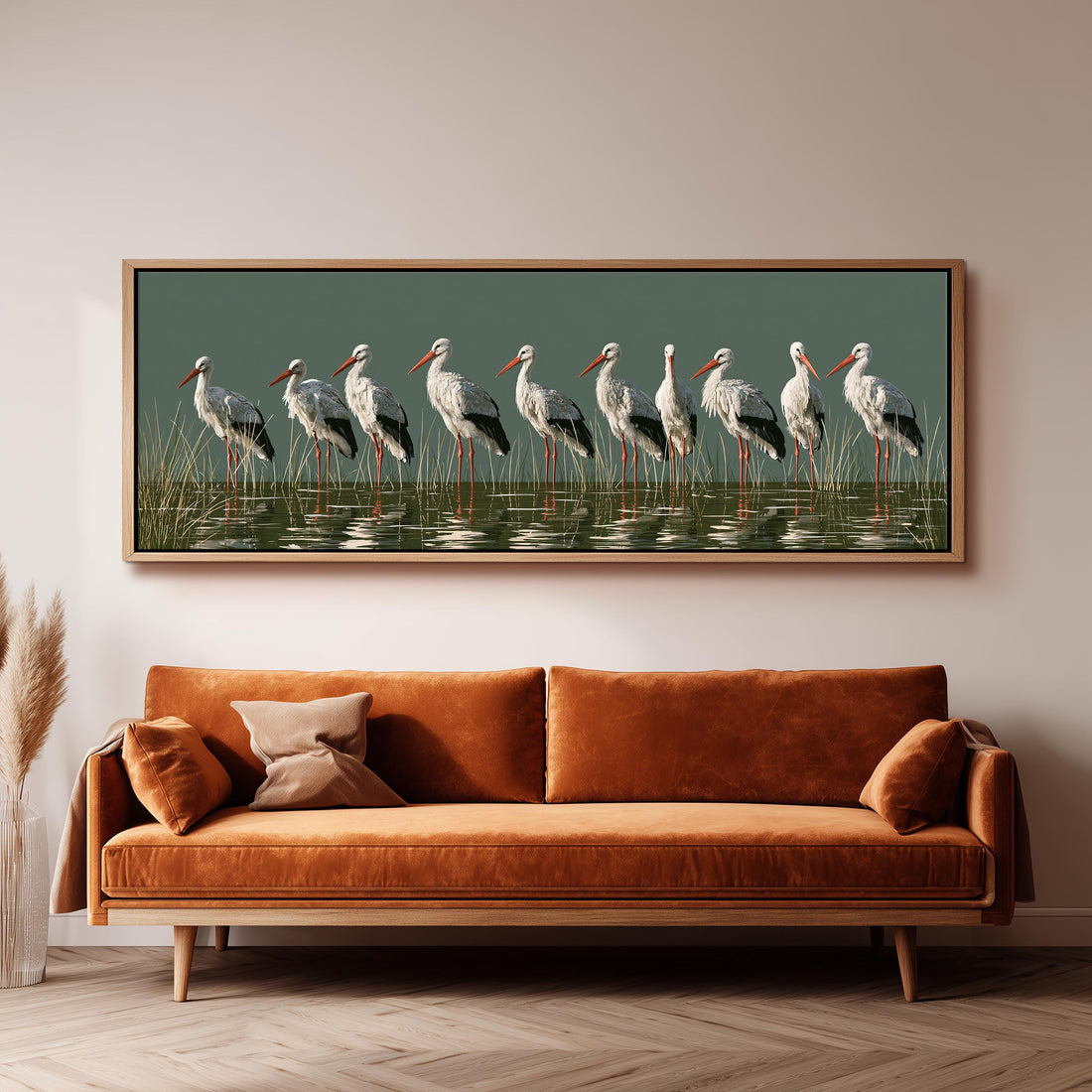 Flock of storks with coral beaks on sage long horizontal canvas print above a sofa in a living room