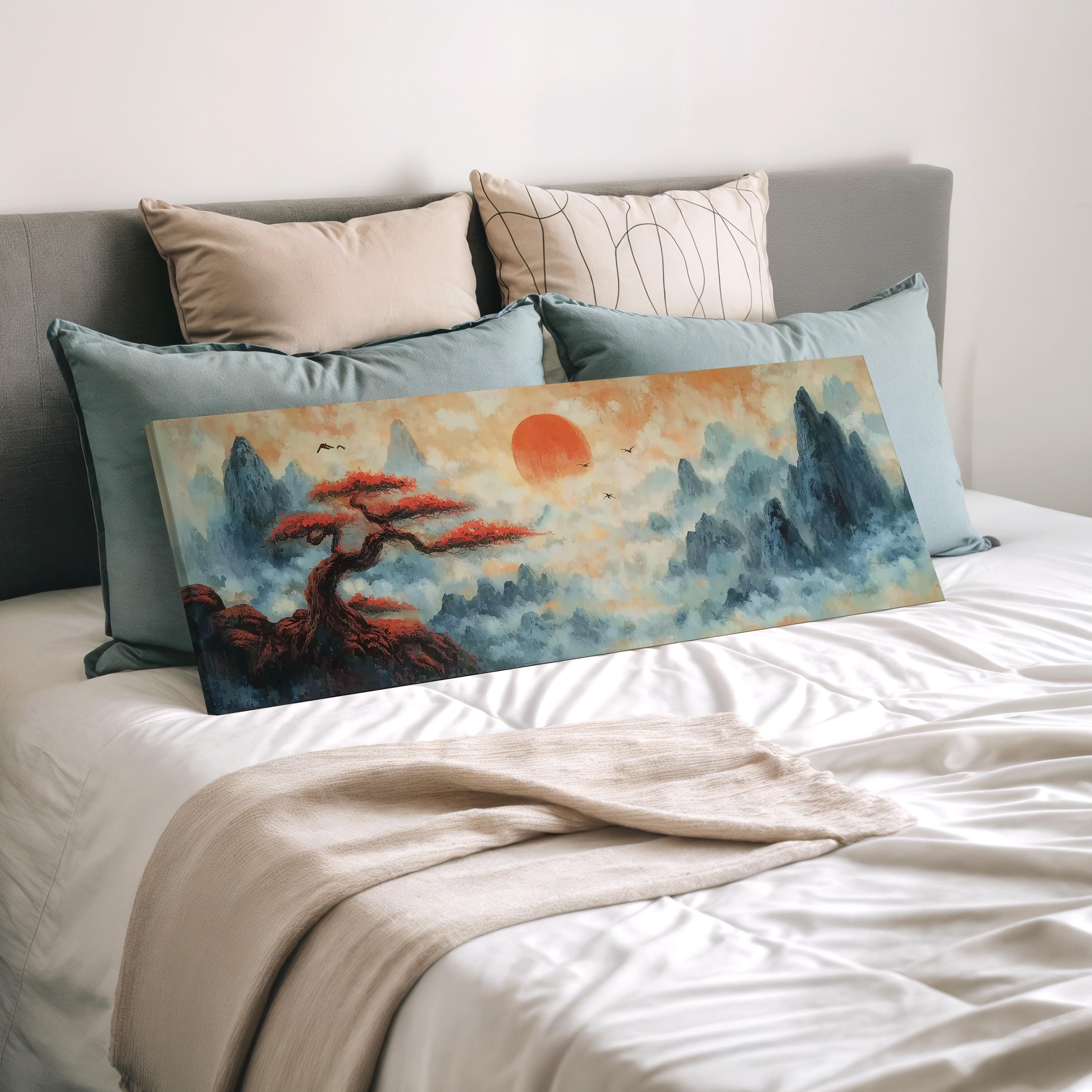 a large landscape painting with a tree and mountains in the background, displayed on a bed with a white comforter and pillows.
