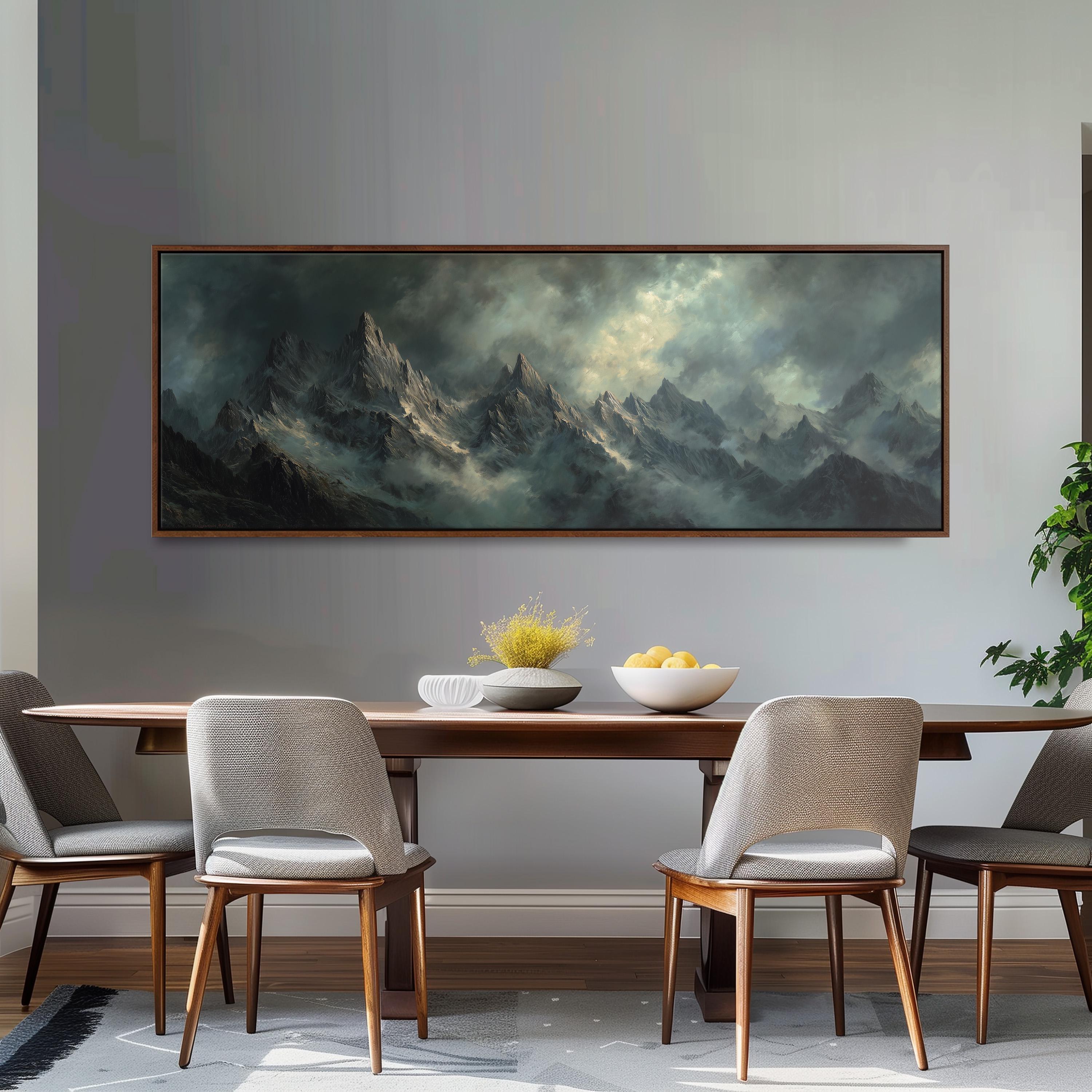 a large painting of a mountainous landscape hanging on a wall above a wooden dining table with four chairs. The painting depicts a dramatic, cloudy sky over the mountains, creating a serene and atmospheric setting.