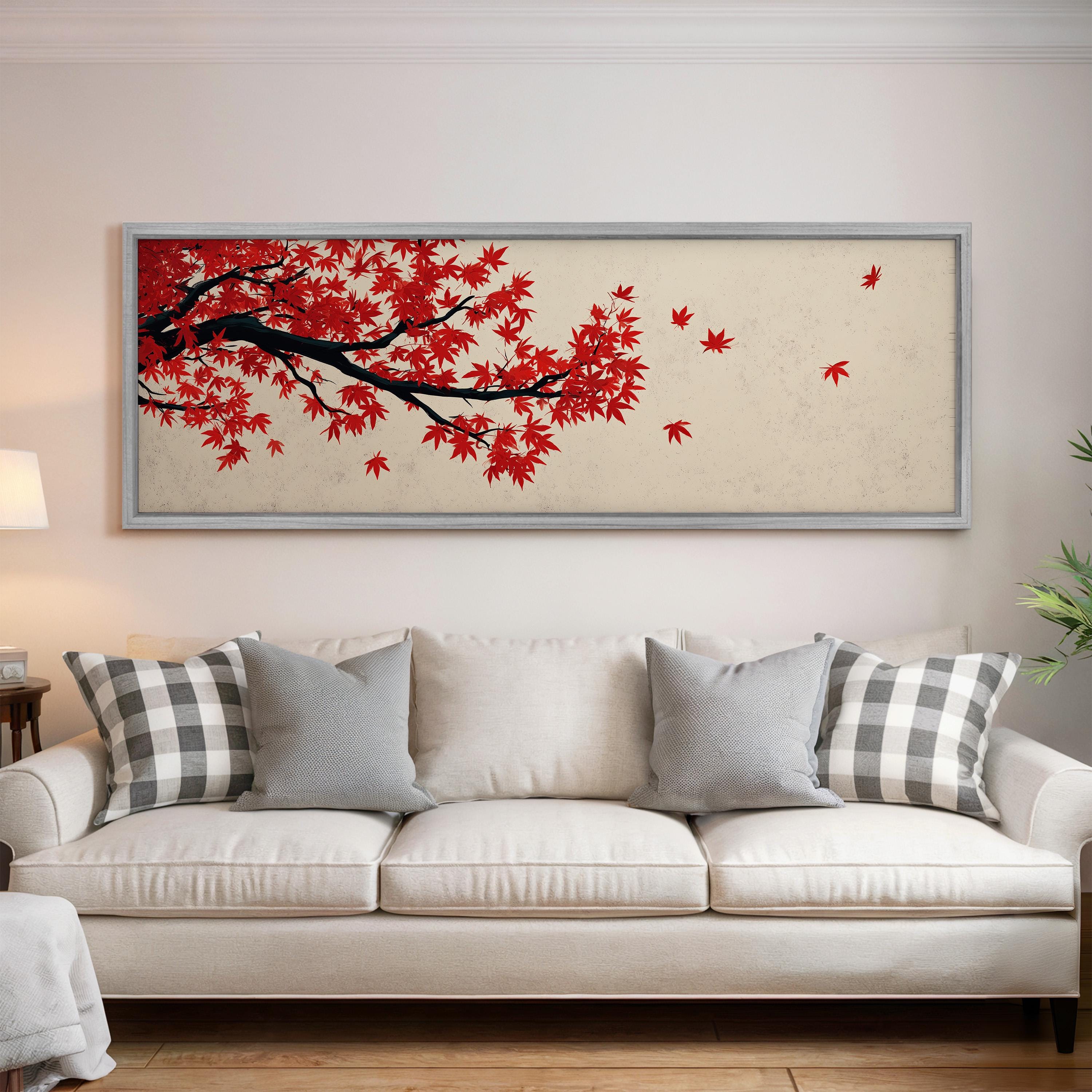 a large framed artwork of a tree with red leaves hanging above a white couch in a living room setting.