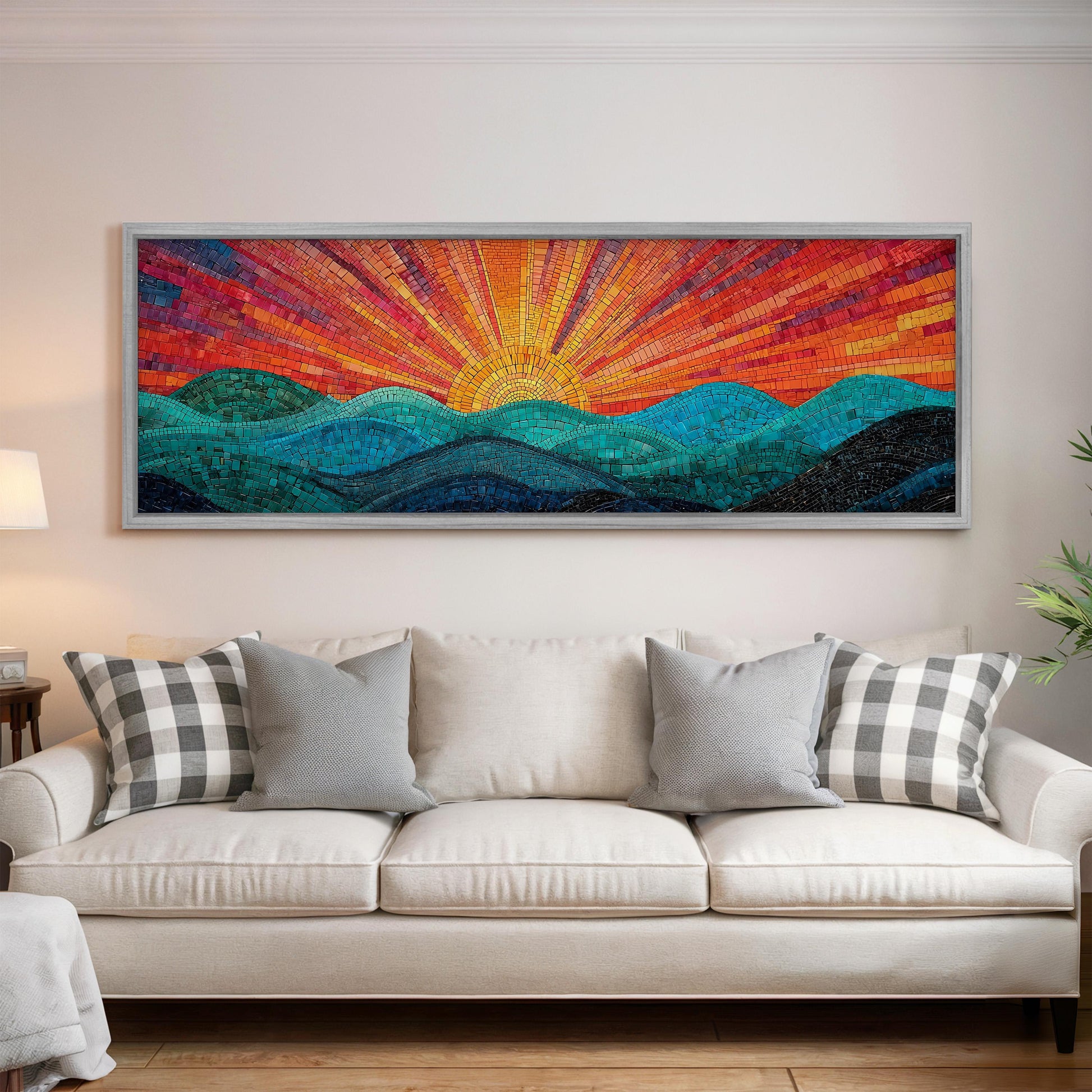 a large, colorful mosaic artwork depicting a sunrise over a mountain landscape, hanging on a wall above a white couch with patterned throw pillows.