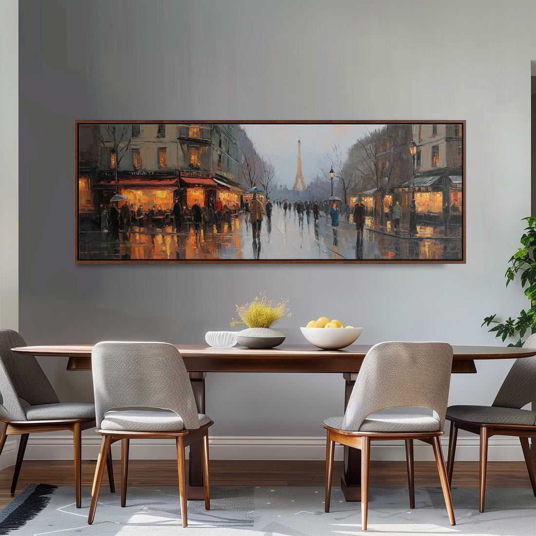 a large painting of a city street scene hanging on a wall above a wooden dining table with four chairs. The painting depicts a rainy day with people walking on the wet street, illuminated by the warm glow of street lamps.