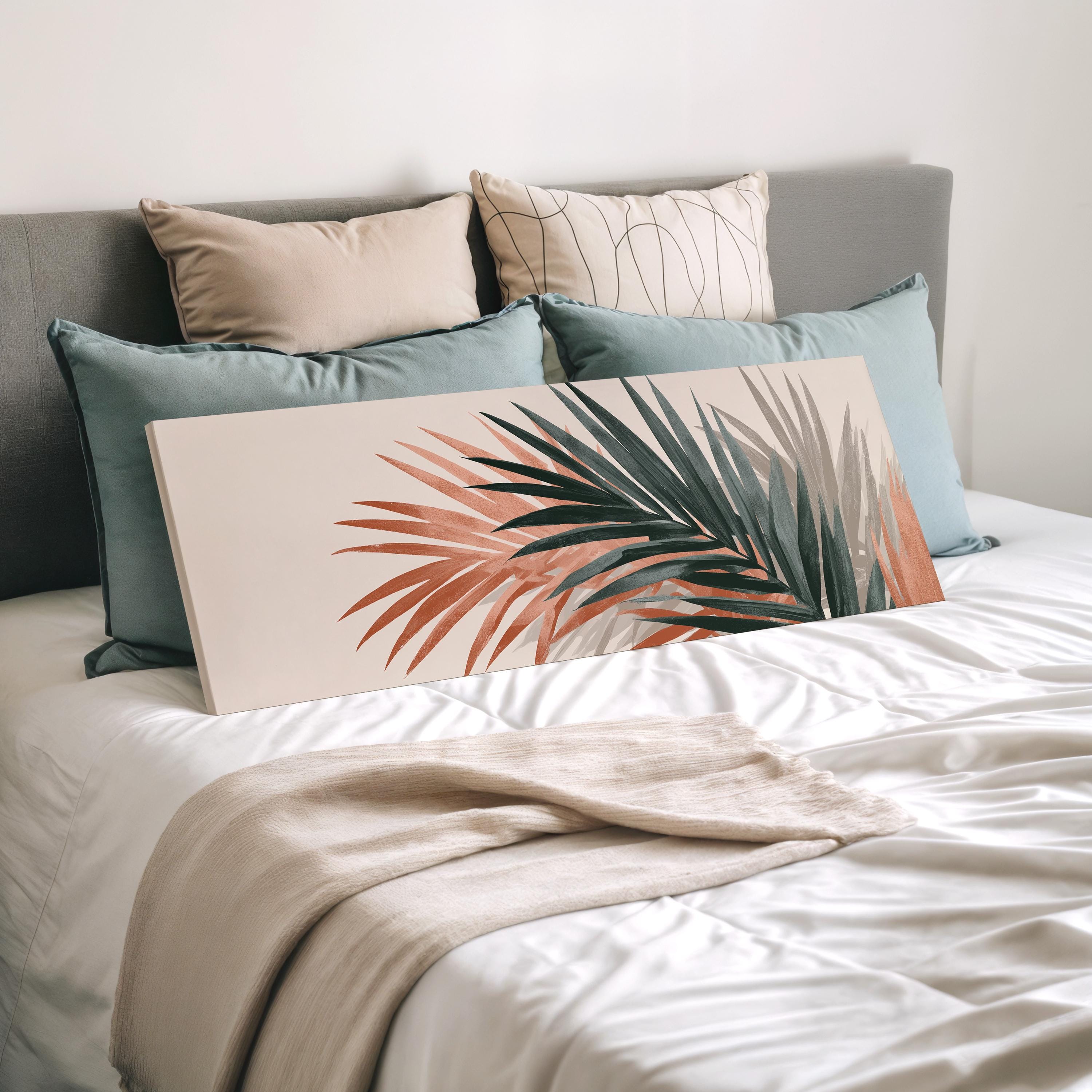a neatly made bed with a white comforter and a large, colorful print of a palm leaf on the bed.