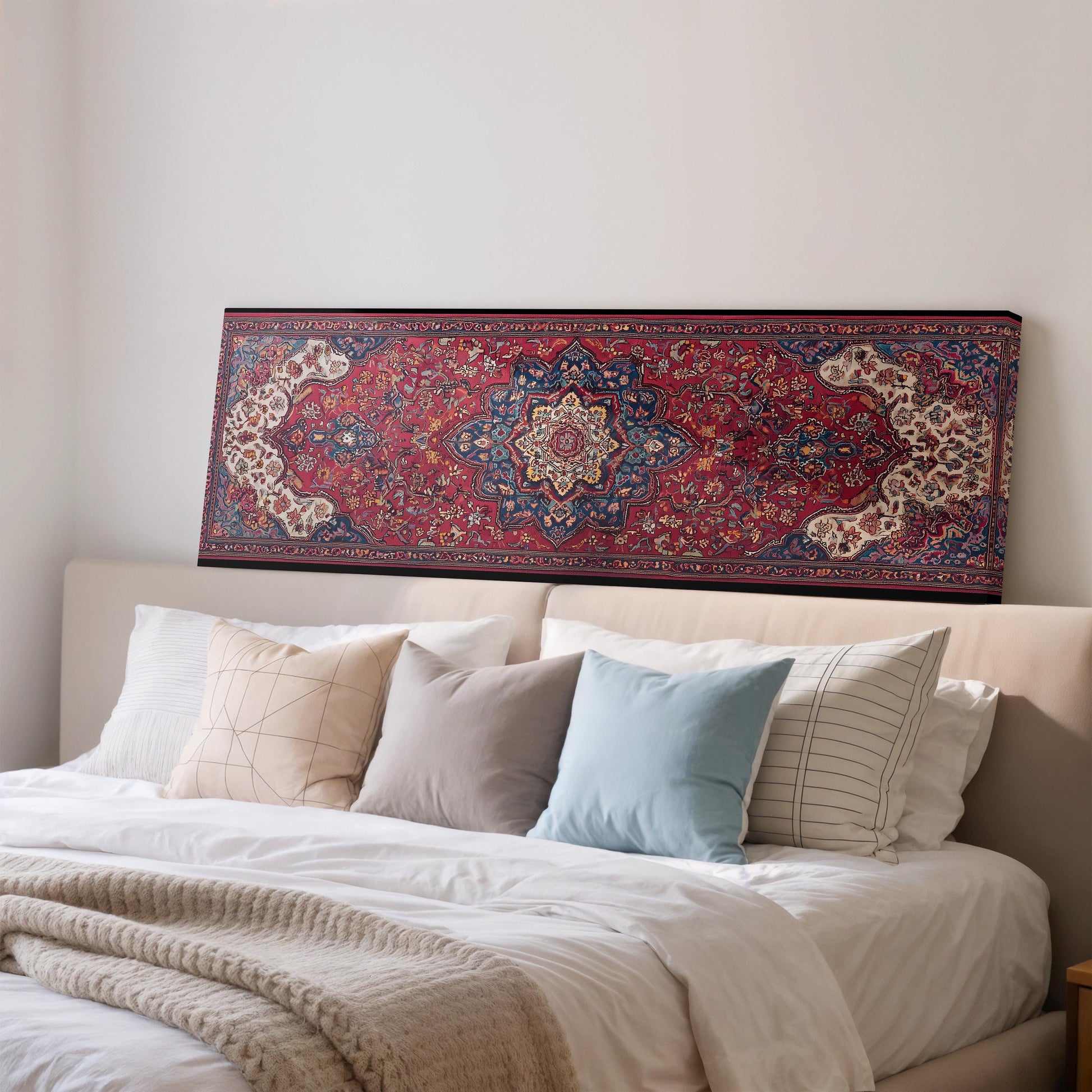 a cozy bedroom with a large bed adorned with white linens and a variety of colorful pillows. Above the bed, there is a large, intricately patterned rug that adds a touch of warmth and texture to the room.