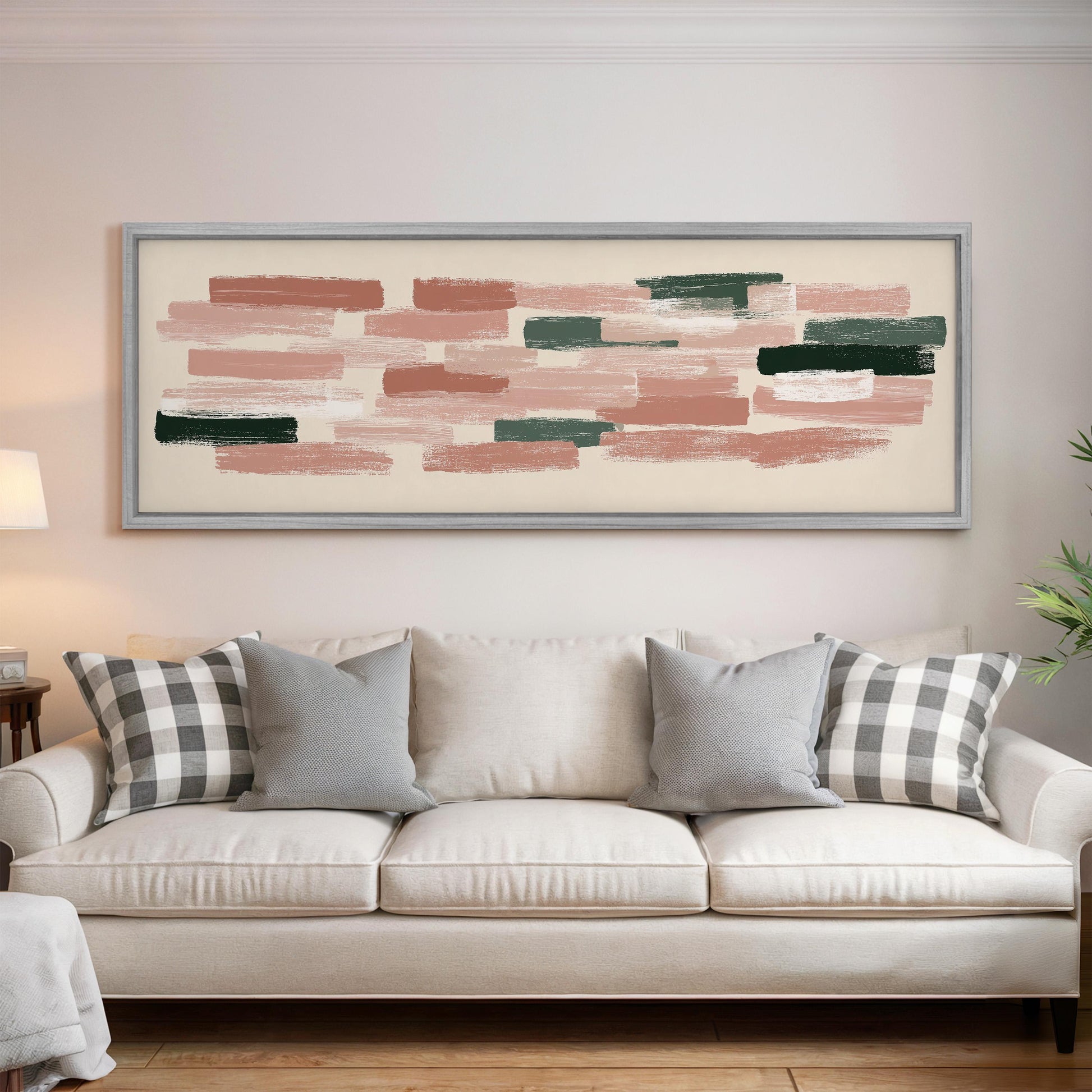 a large abstract painting hanging on a wall above a white sofa with gray and white patterned pillows.