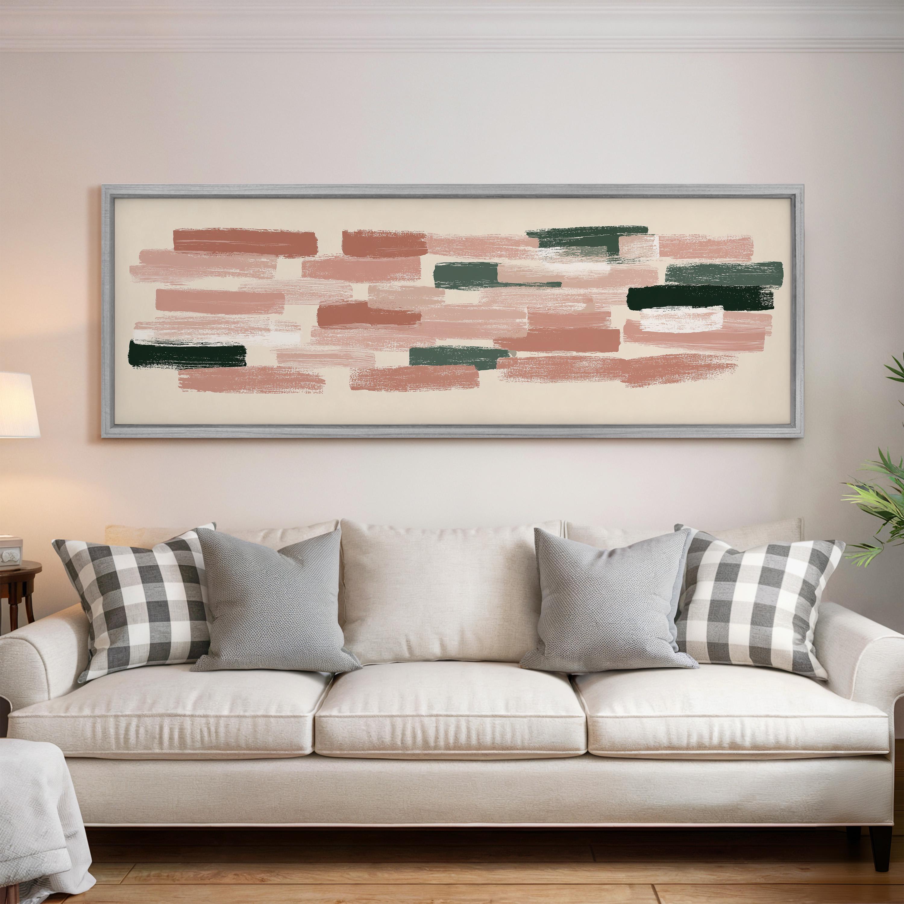 a large abstract painting hanging on a wall above a white sofa with gray and white patterned pillows.