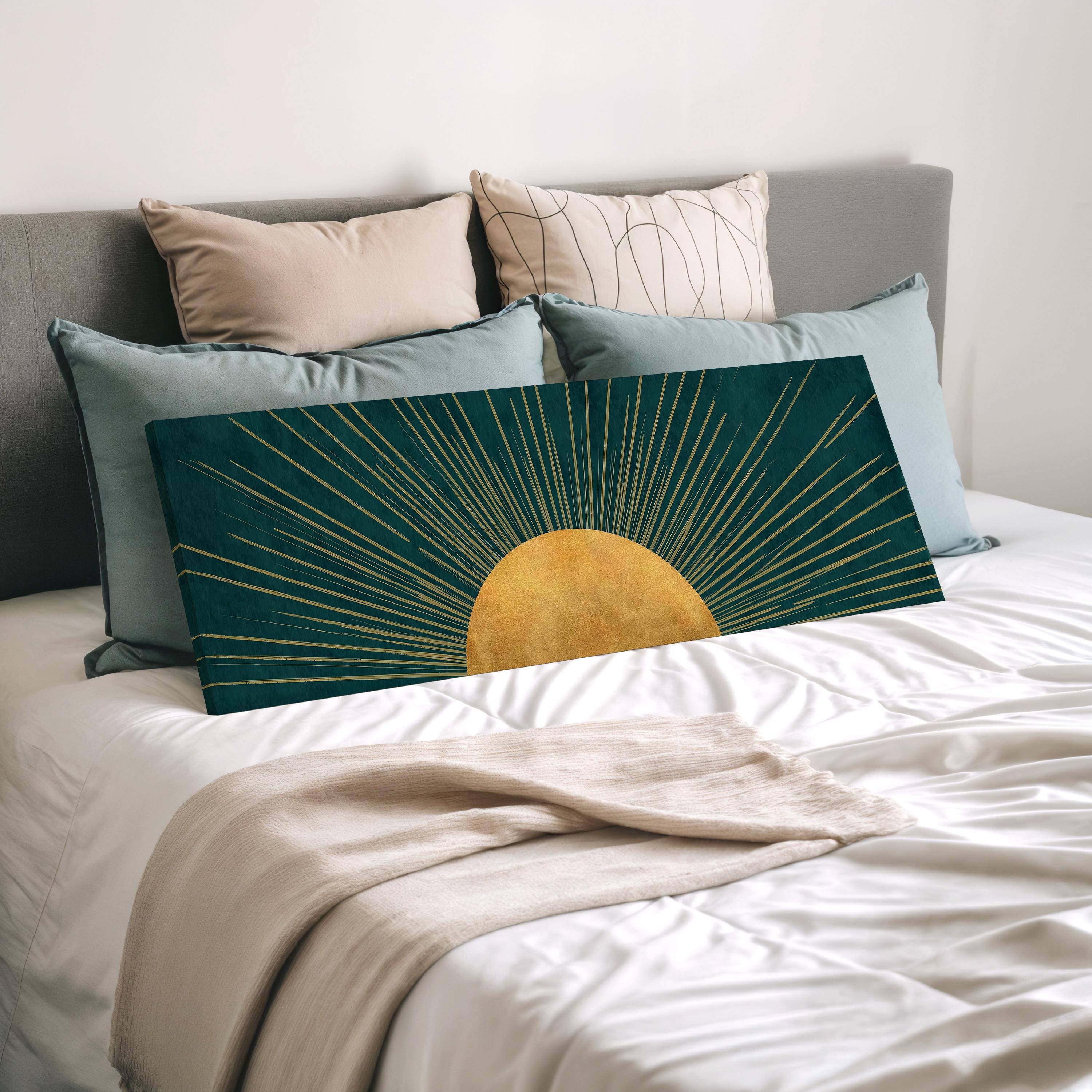 a bed with a green and gold sun-like design on the pillow, surrounded by various pillows in different colors and patterns.