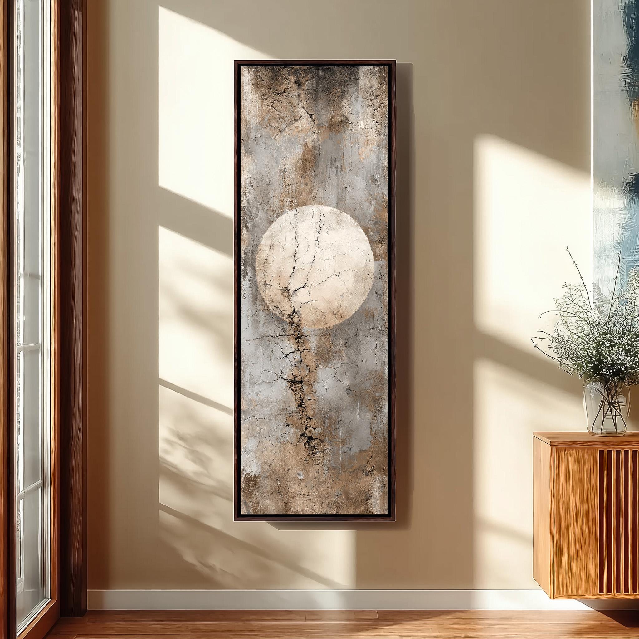 a large, abstract painting hanging on a wall, with a wooden cabinet and a vase of flowers placed next to it.