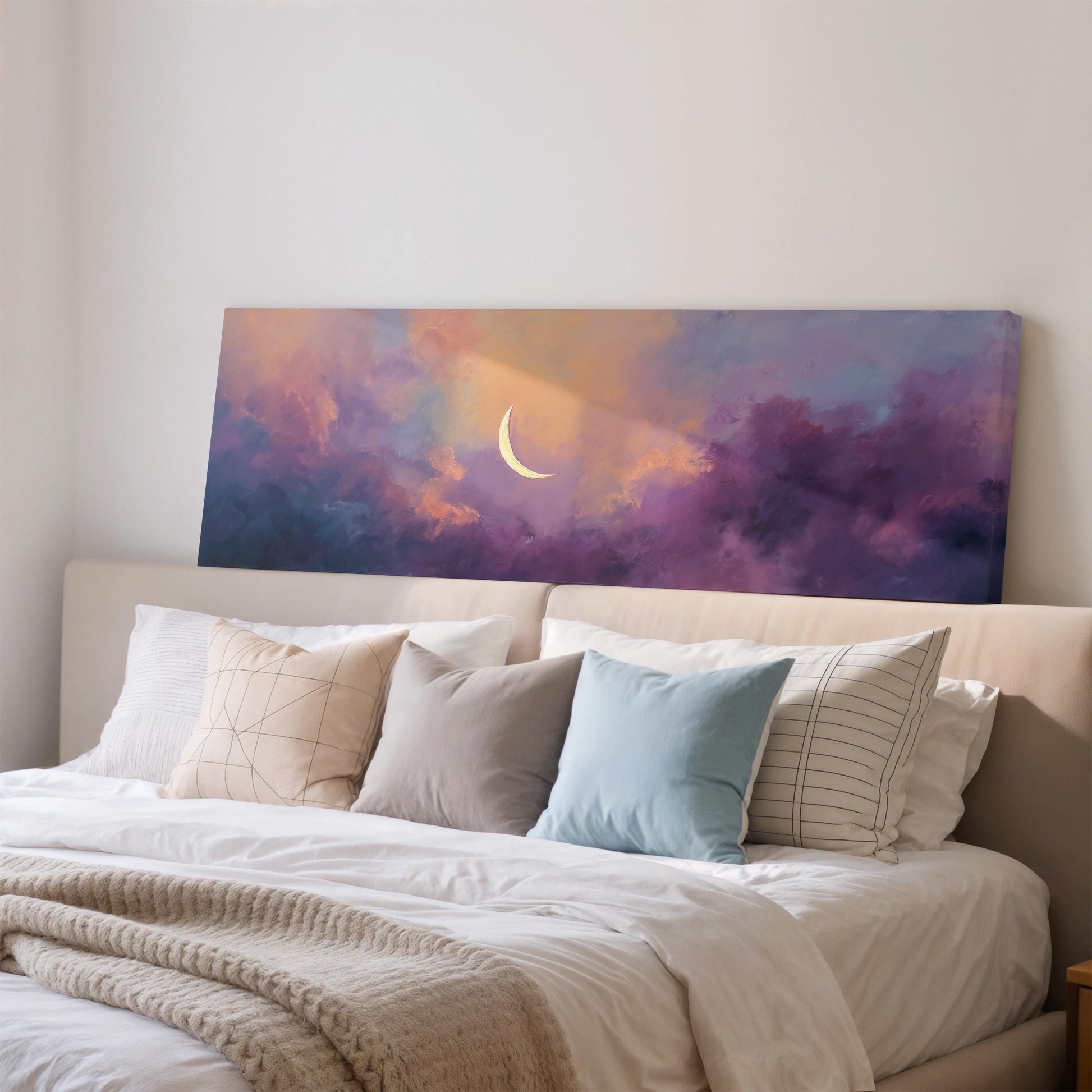 a large bed with white sheets and pillows, and a painting of a crescent moon on the wall above it.