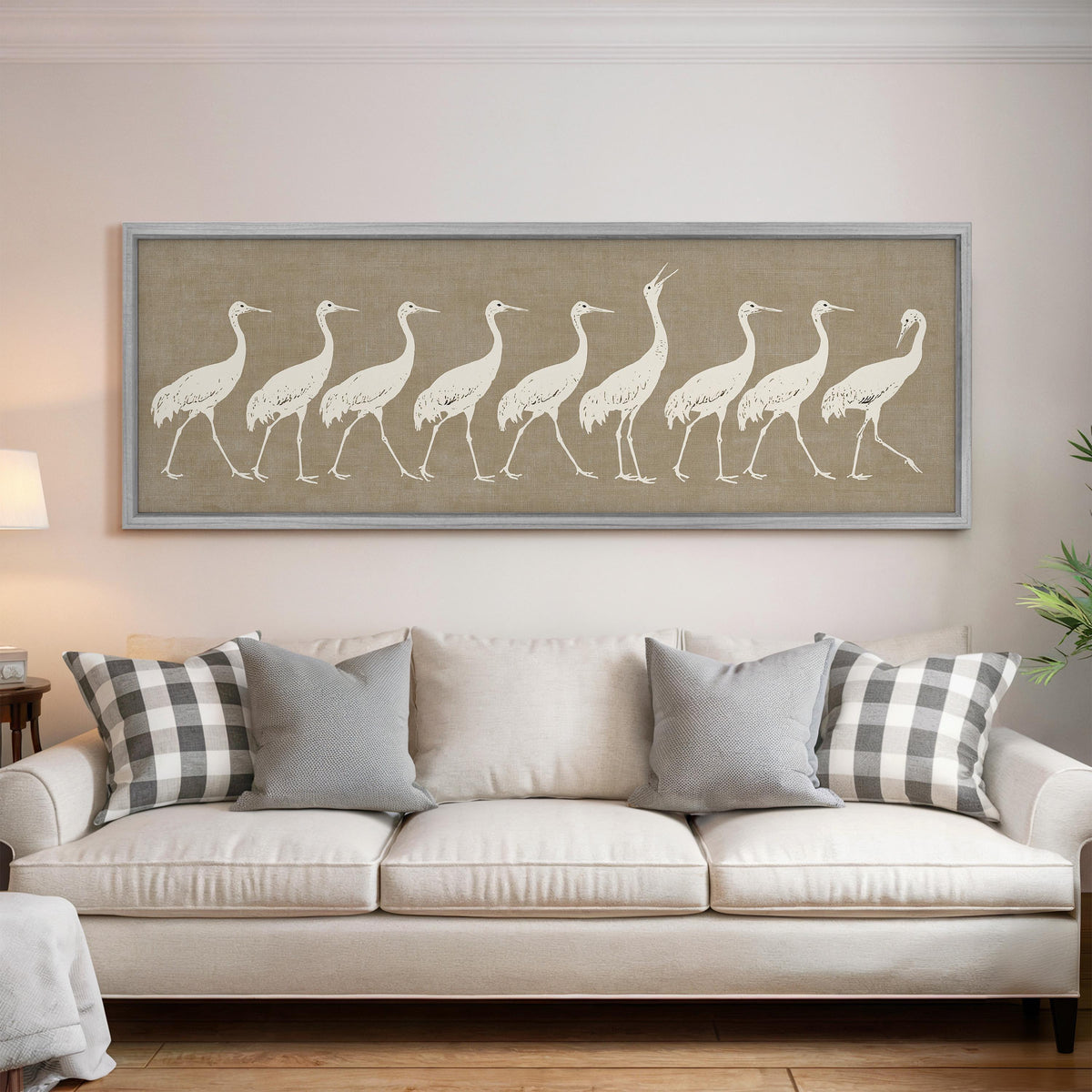 Procession of white cranes on linen panoramic canvas print above a white sofa in a bright living room