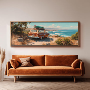 a large framed painting of a vintage car with a surfboard on top, set against a scenic coastal landscape.