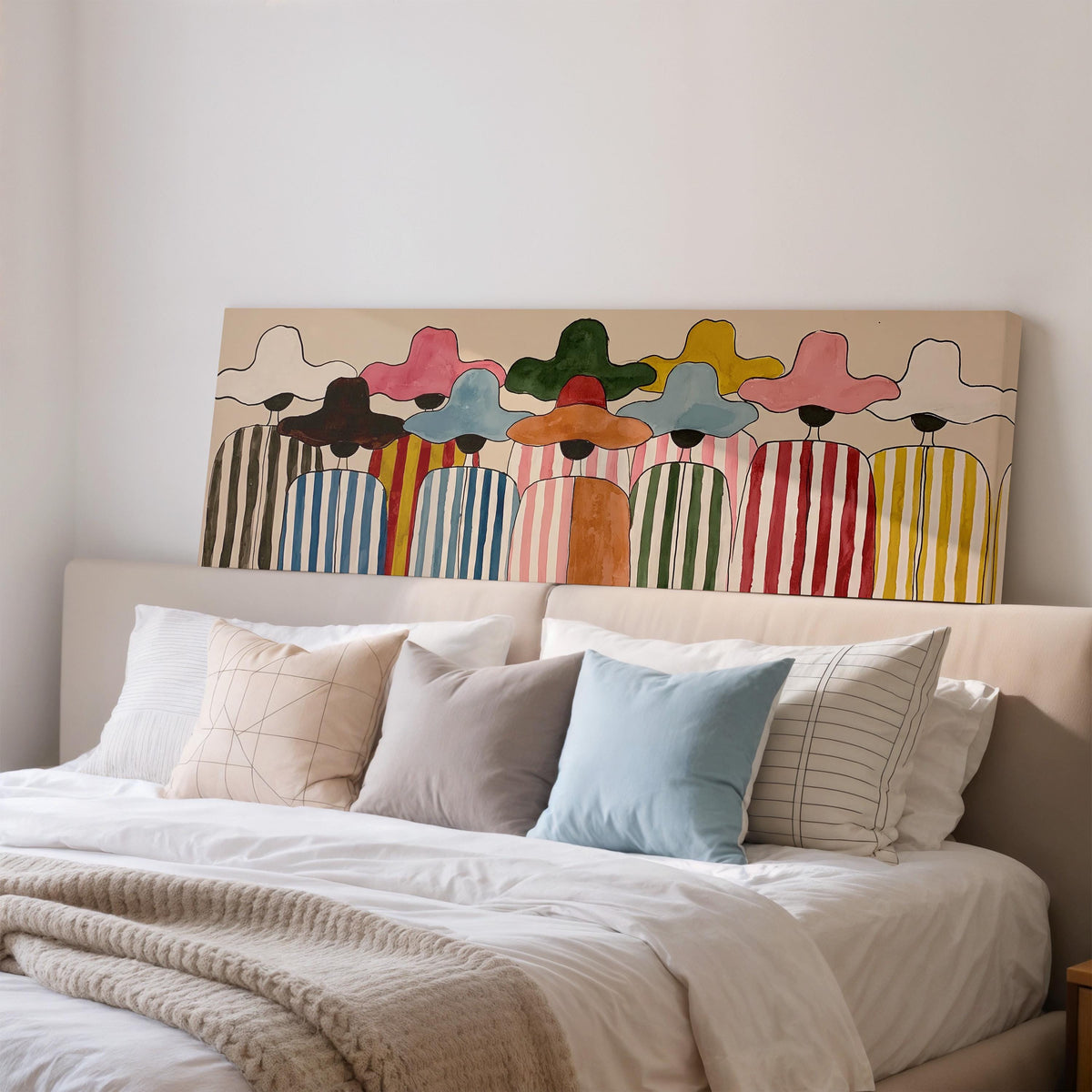Crowd of figures in colorful sun hats wide panoramic canvas print above a bed in a bedroom