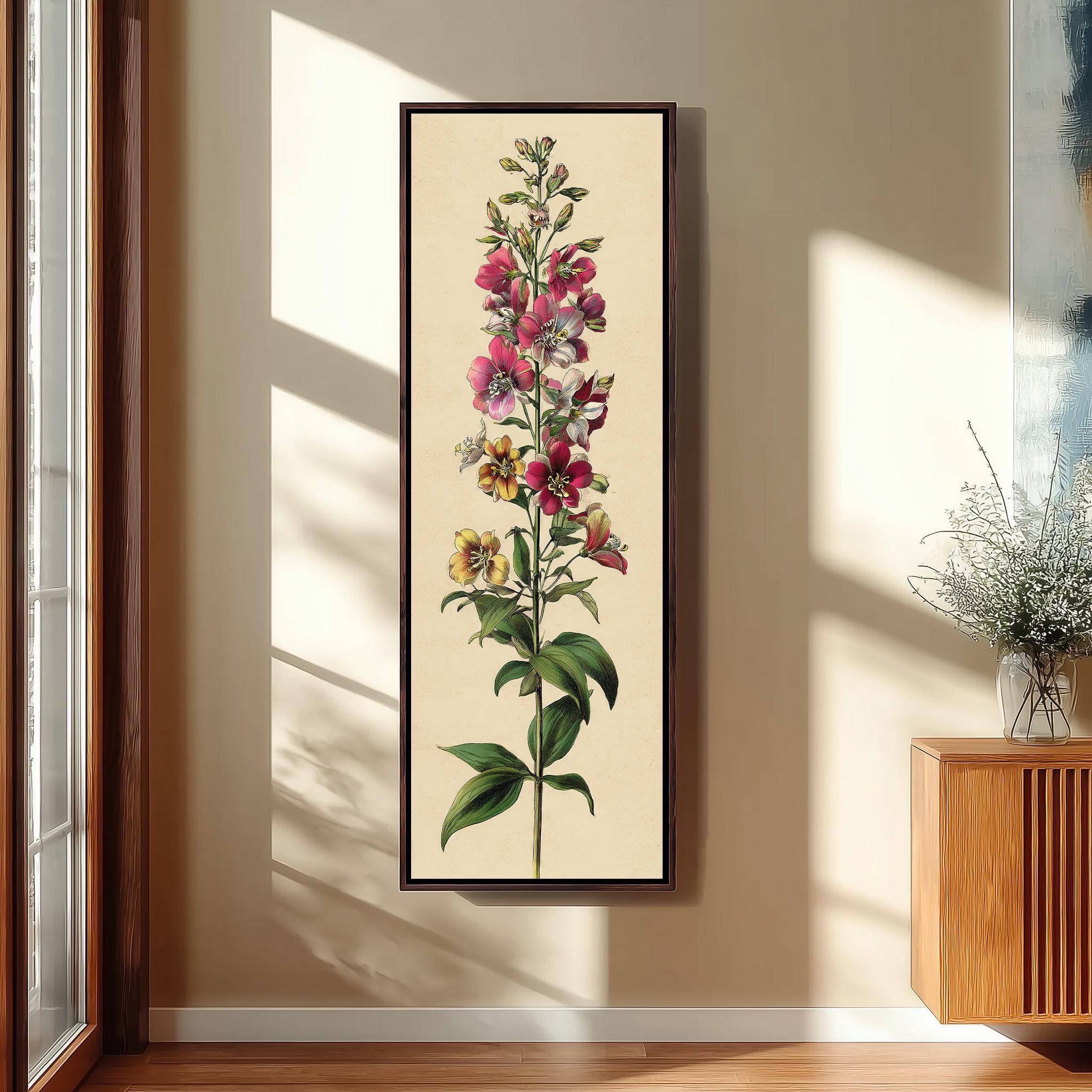 a framed botanical illustration of a flower with a tall stem and multiple blooms, hanging on a wall in a room with a wooden cabinet and a vase of flowers.