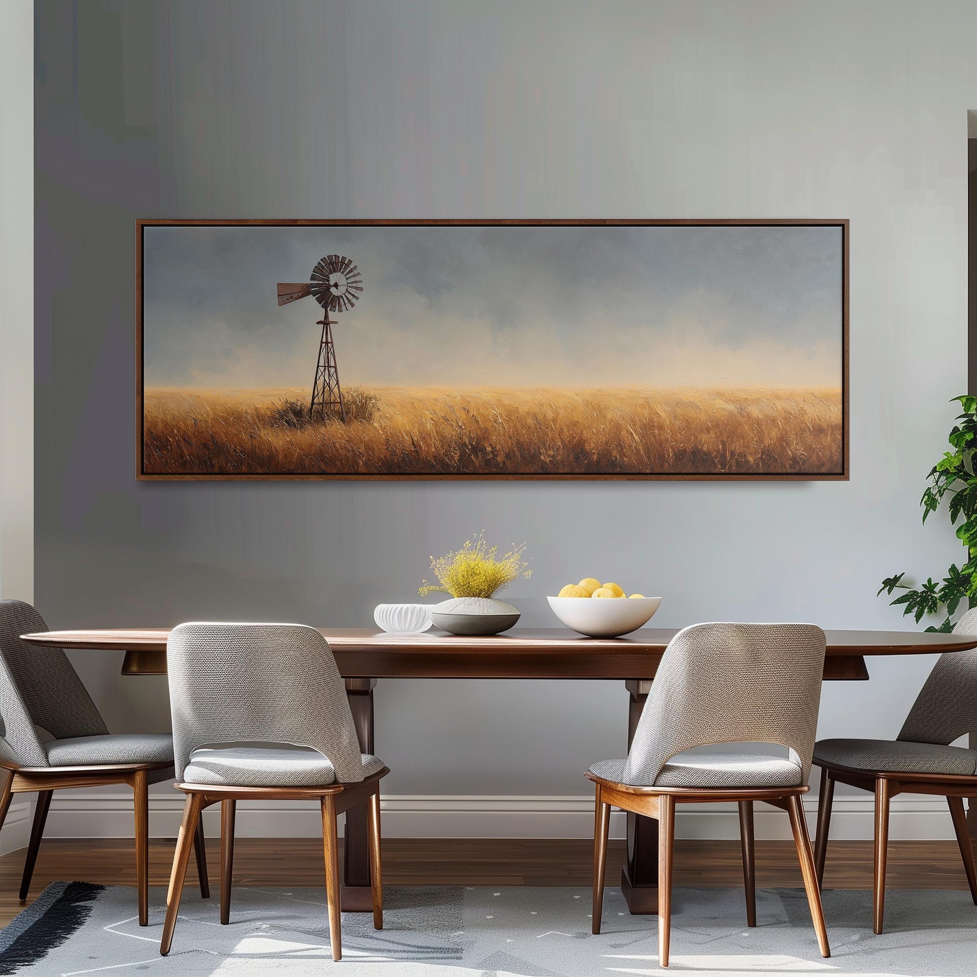 a dining room with a large painting of a windmill in the background, a wooden table with chairs, and a bowl of fruit on the table.