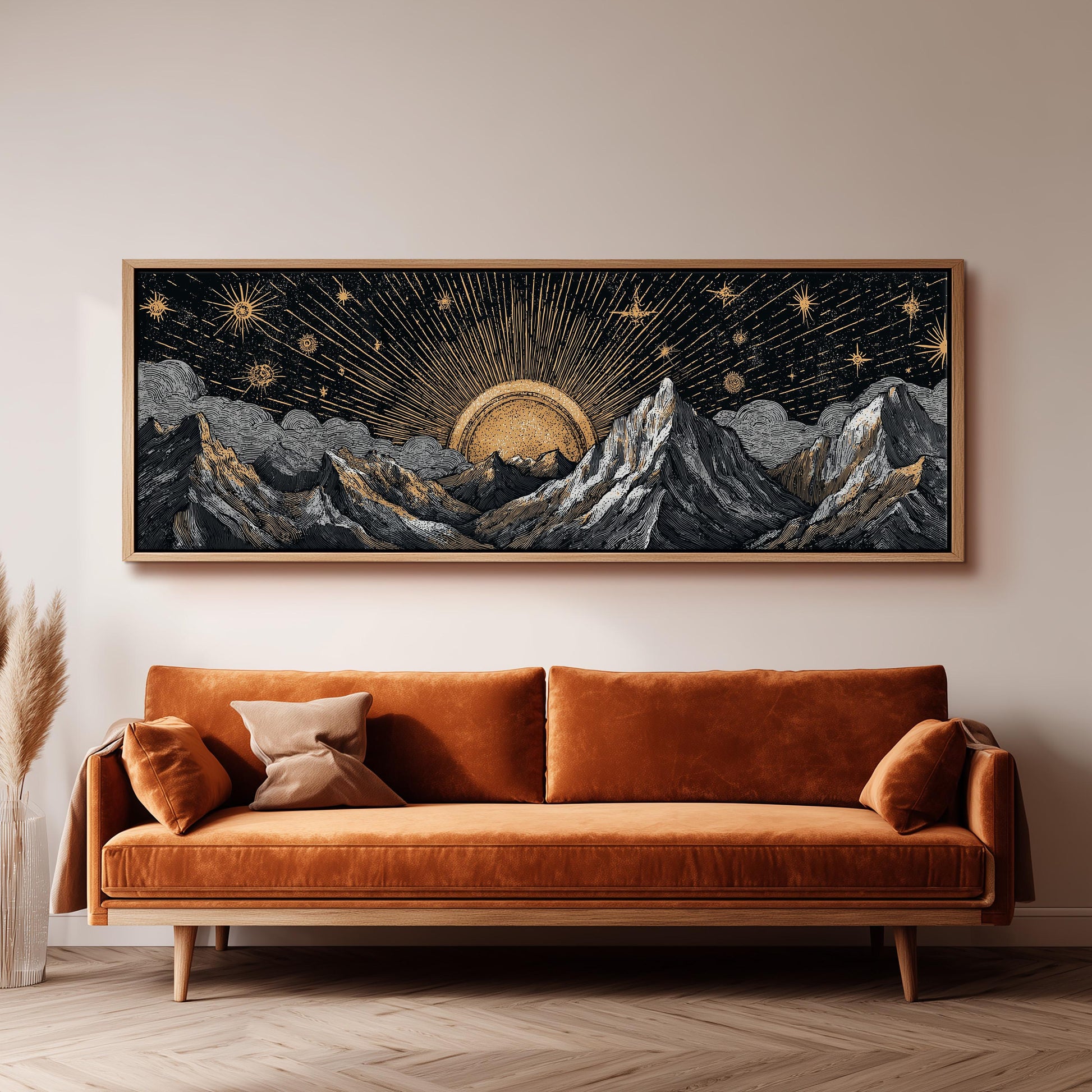 a large, framed artwork depicting a mountainous landscape with a sun and stars in the sky, hanging above a brown sofa in a living room setting.