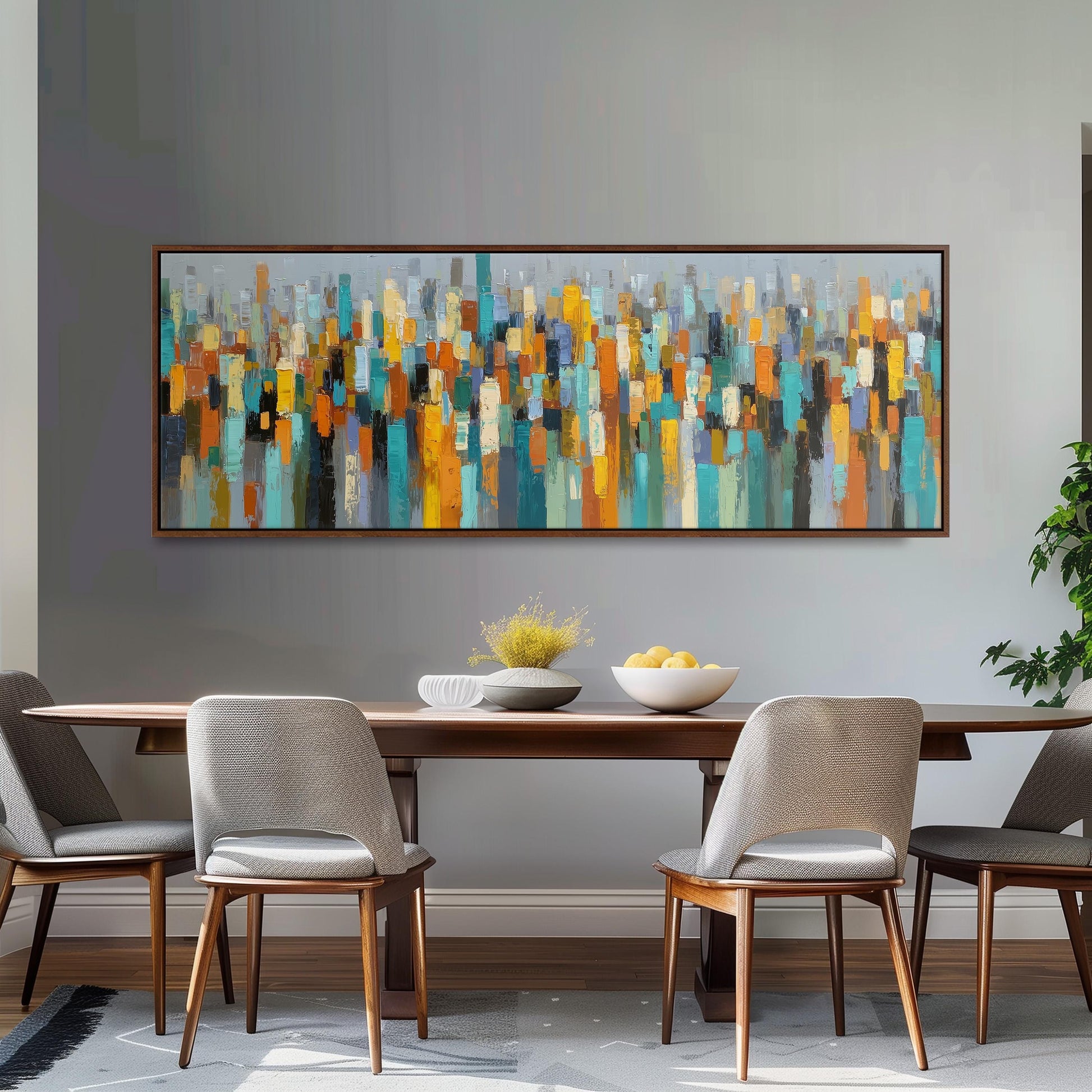 a modern dining room with a large abstract painting hanging on the wall above a wooden dining table. The table is set with a bowl of fruit and a vase of flowers, creating a welcoming atmosphere. The room is furnished with four chairs, two on each side of the table, and a potted plant is placed on the right side of the room.