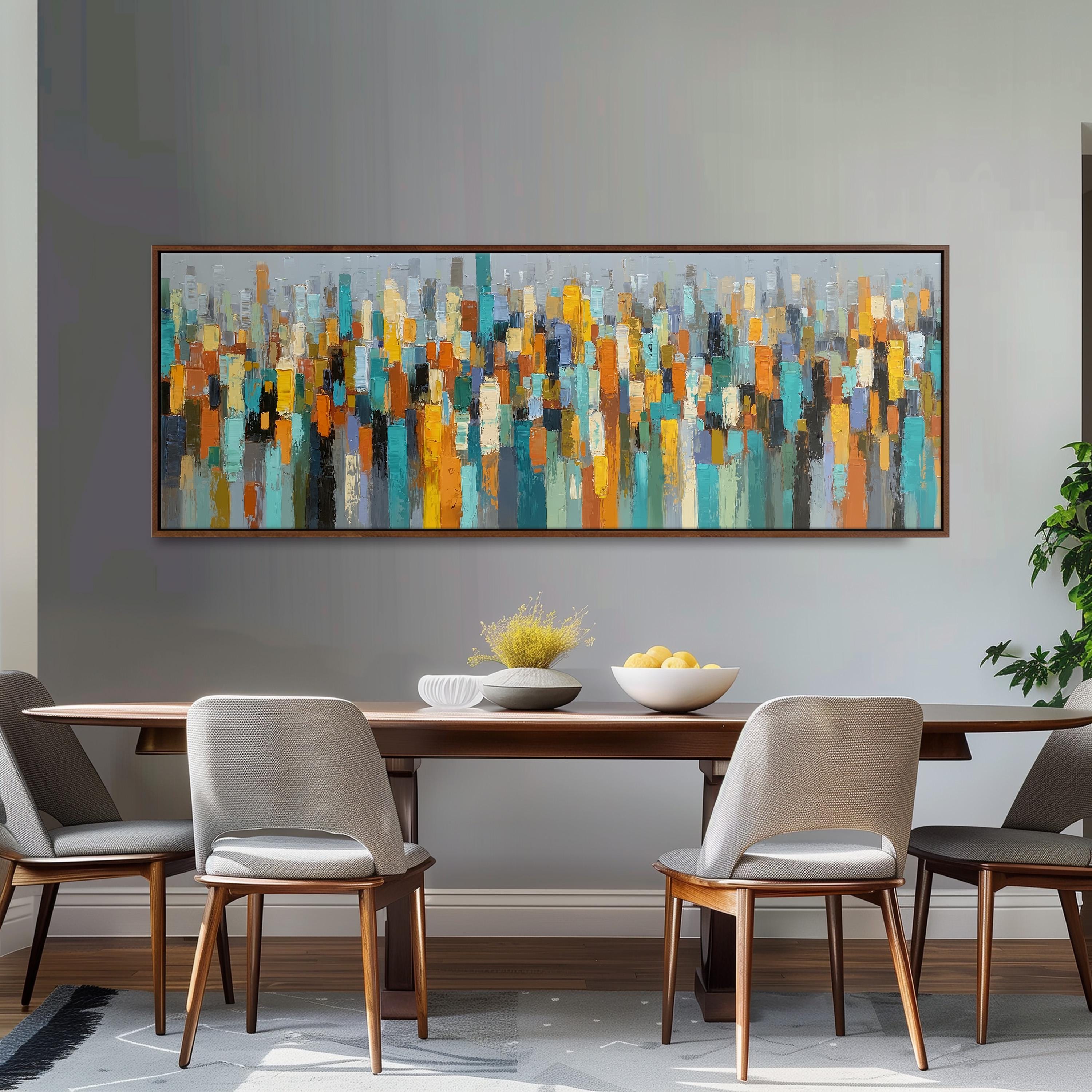 a modern dining room with a large abstract painting hanging on the wall above a wooden dining table. The table is set with a bowl of fruit and a vase of flowers, creating a welcoming atmosphere. The room is furnished with four chairs, two on each side of the table, and a potted plant is placed on the right side of the room.