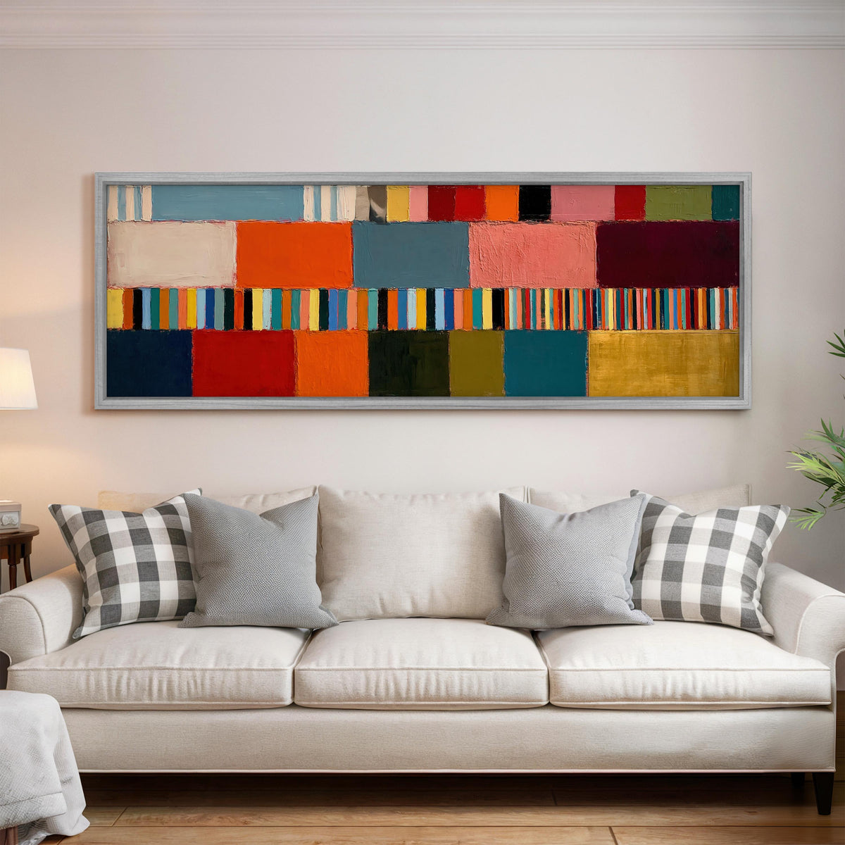 Rainbow patchwork color bands panoramic canvas print above a white sofa in a bright living room