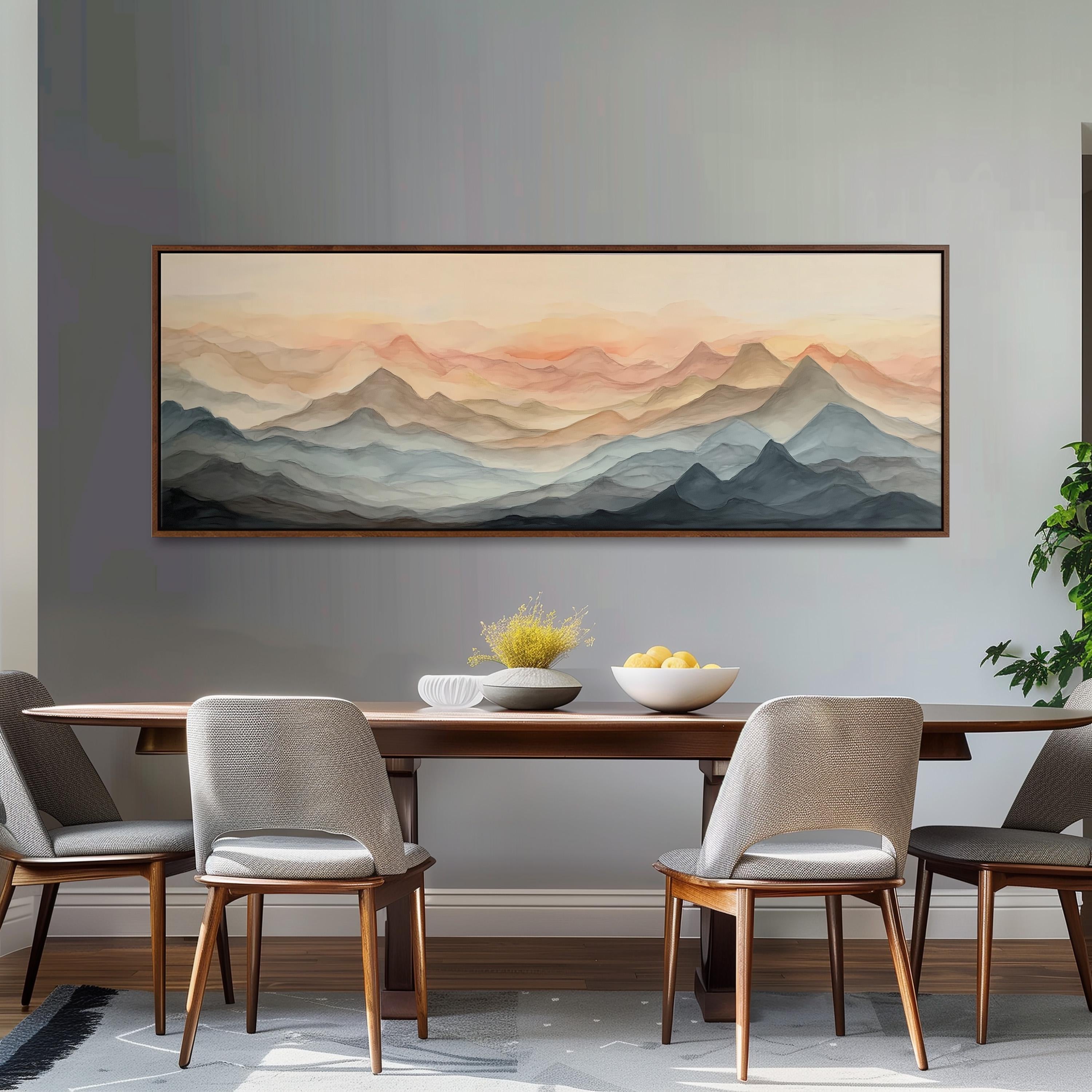 a dining room with a large painting of mountains hanging on the wall above a wooden dining table with four chairs. The painting depicts a scenic landscape with mountains in shades of orange and blue, creating a serene and picturesque atmosphere.