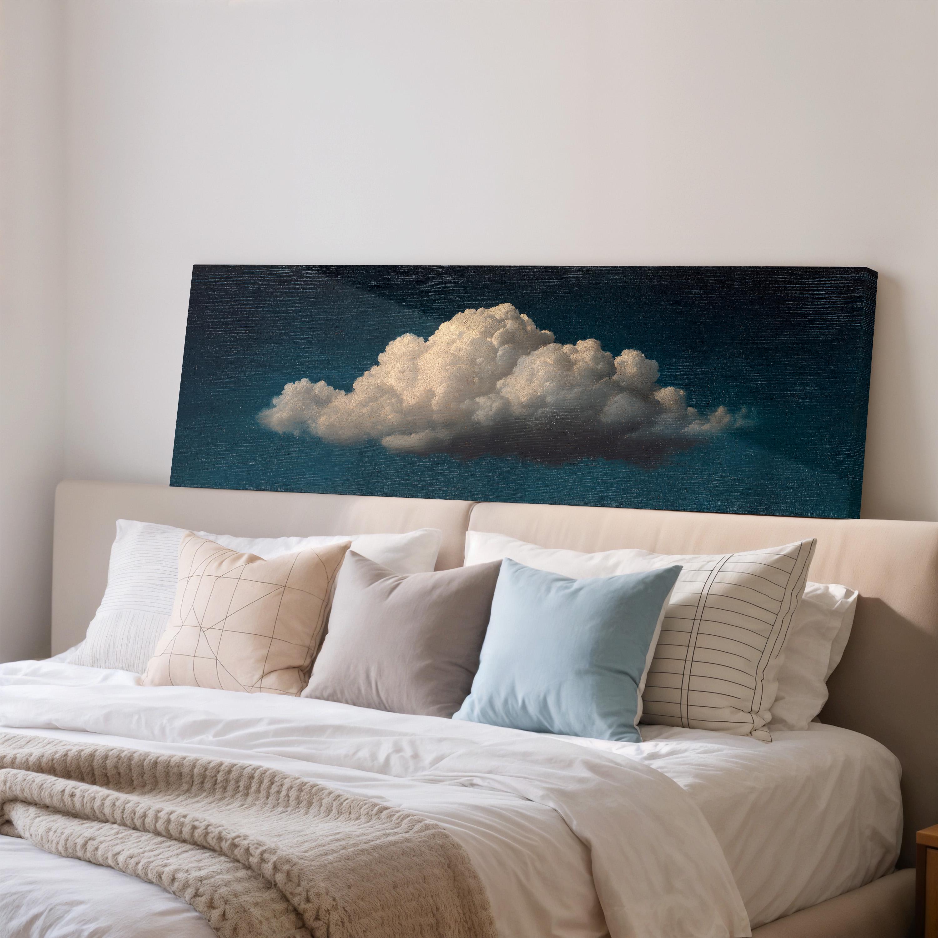 a serene bedroom scene with a large bed adorned with white pillows and a gray throw blanket. Above the bed, a large canvas print of a cloud is displayed, creating a calming and peaceful atmosphere in the room.