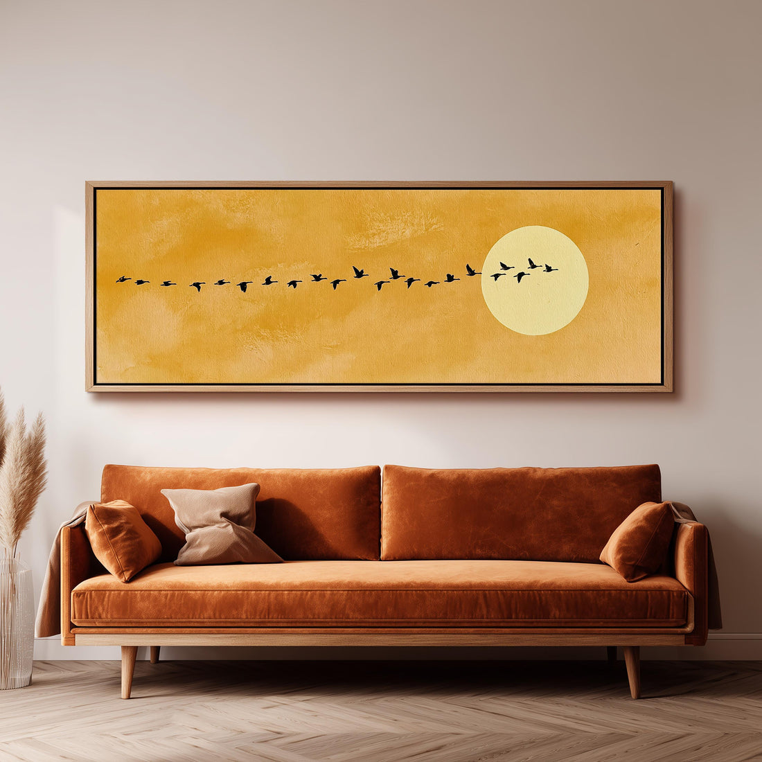 Geese flying toward a pale sun on mustard long horizontal canvas print above a sofa in a living room