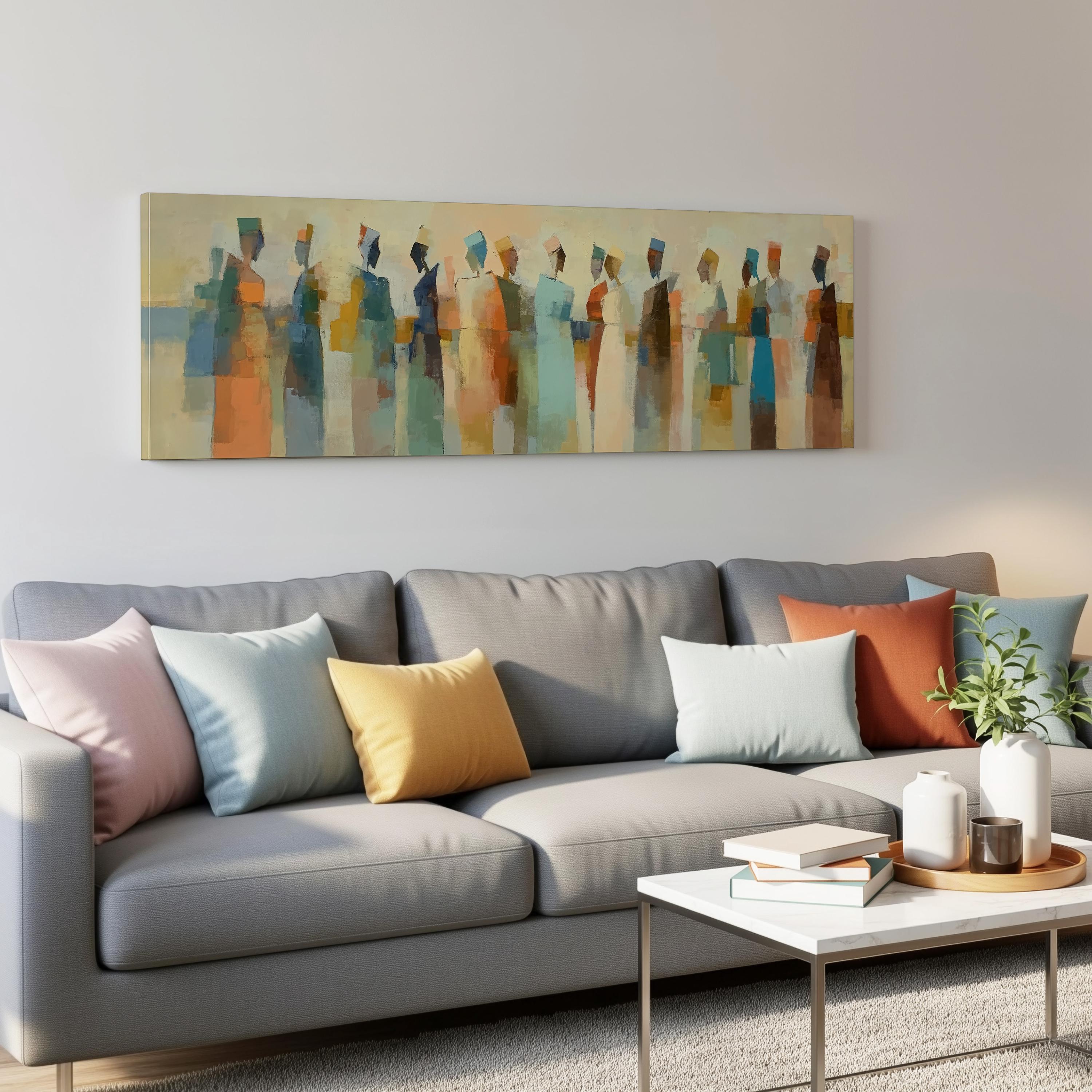 a modern living room with a gray sofa adorned with colorful throw pillows. Above the sofa, there is a large abstract painting depicting a group of stylized human figures in various colors. The room also includes a coffee table with books and a plant, creating a cozy and inviting atmosphere.