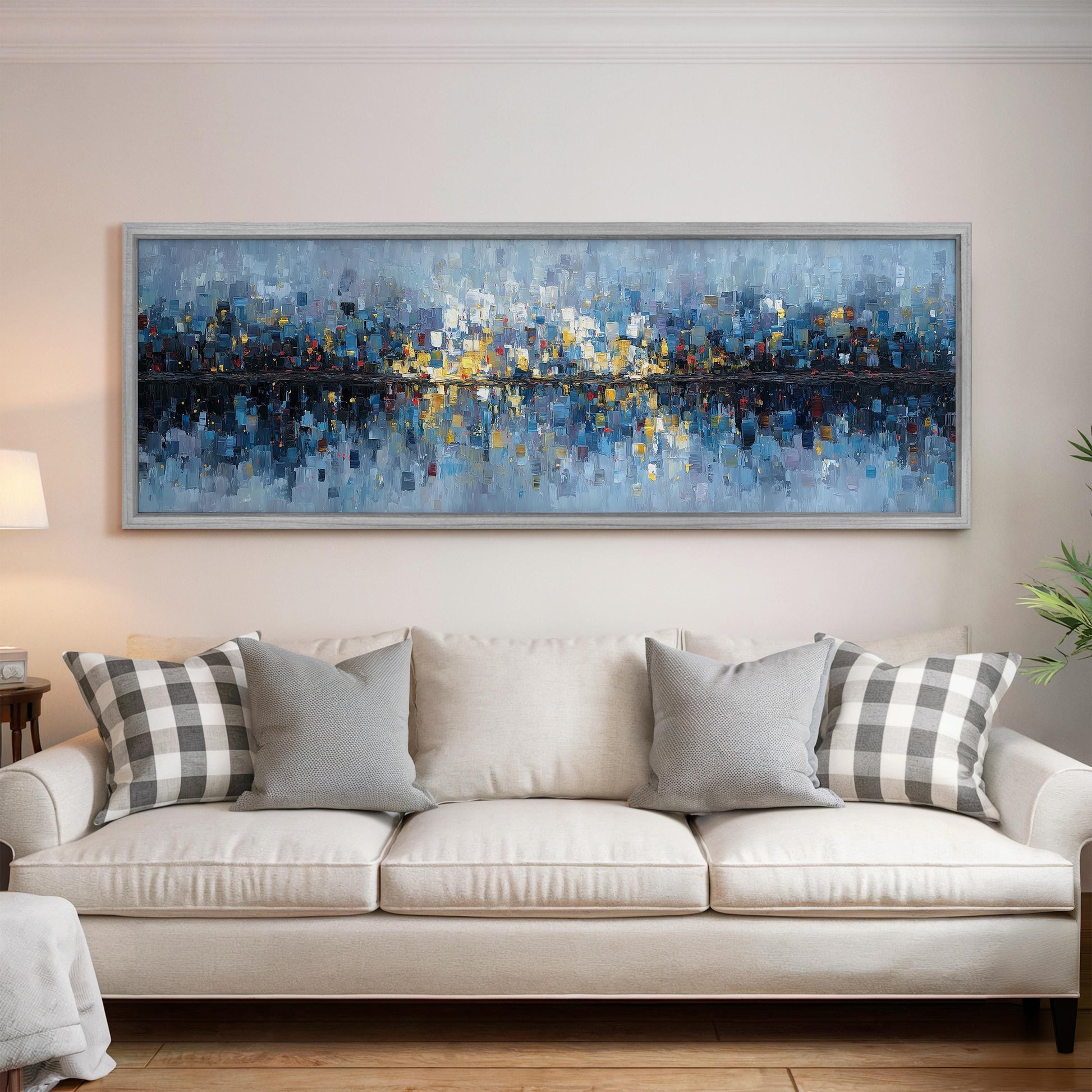 a large, colorful painting of a cityscape hanging on a wall above a white couch with gray and white patterned pillows.
