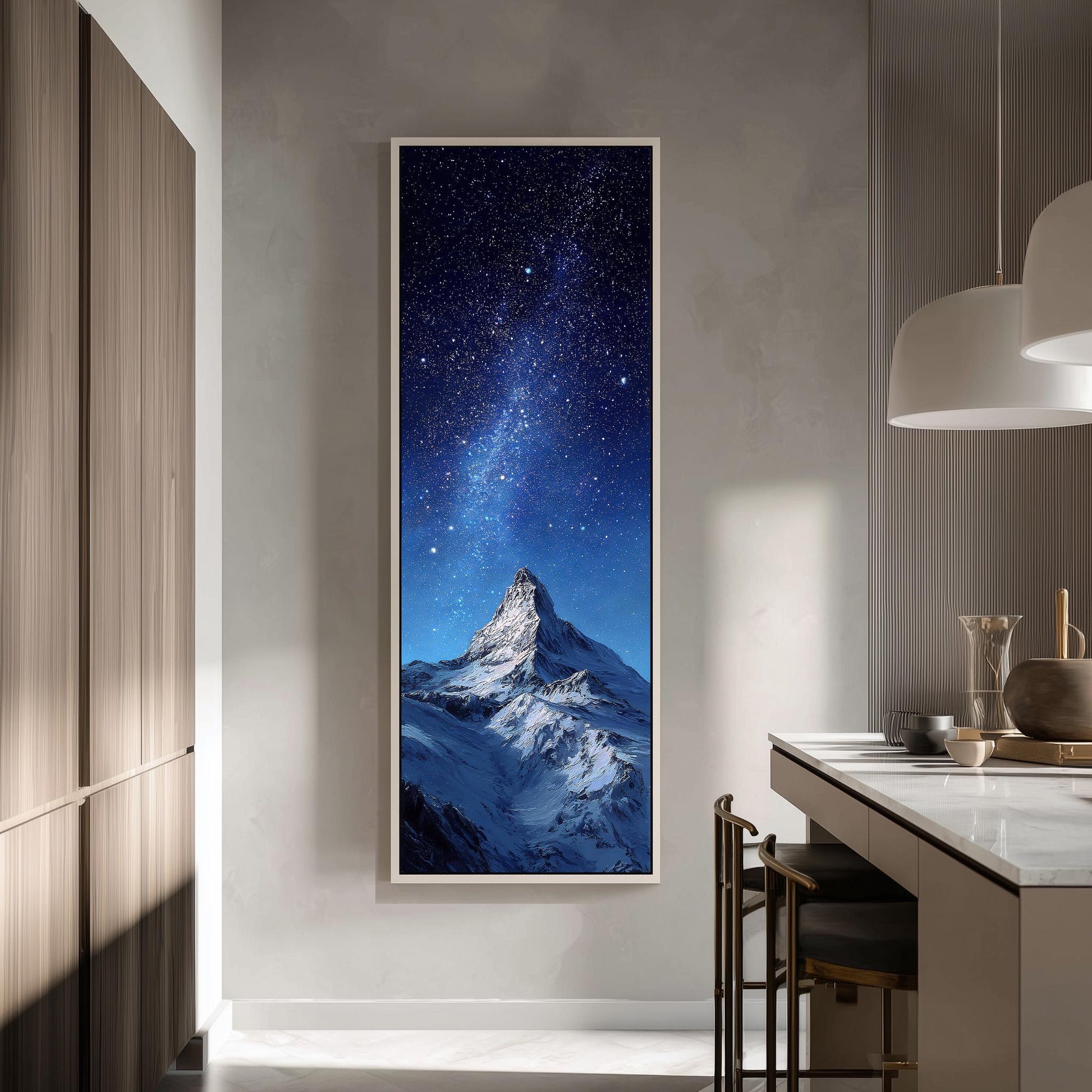 a large framed painting of a snowy mountain peak under a starry night sky, hanging on a wall in a modern kitchen.