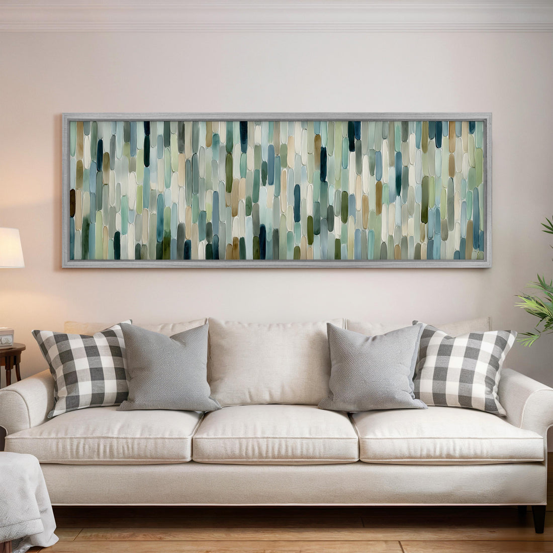a large, rectangular abstract painting hanging on a wall above a white couch with gray and white plaid throw pillows.