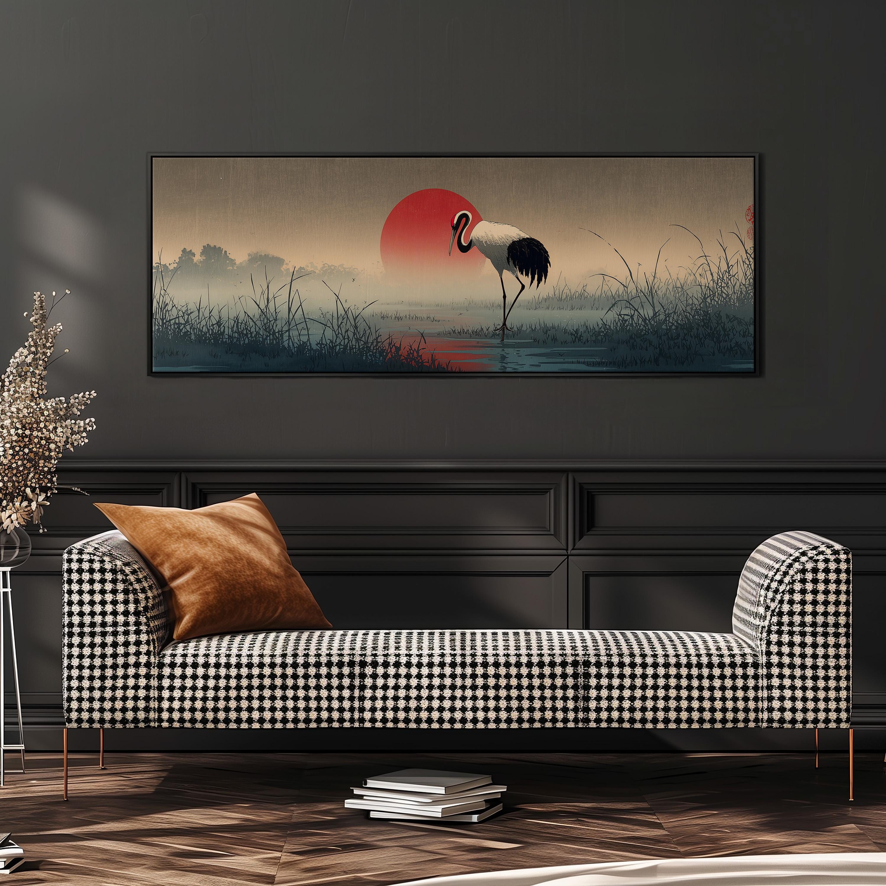 a large black and white checkered sofa with a brown throw pillow, positioned in front of a wall with a framed painting depicting a crane standing on a lake with a red sun in the background.