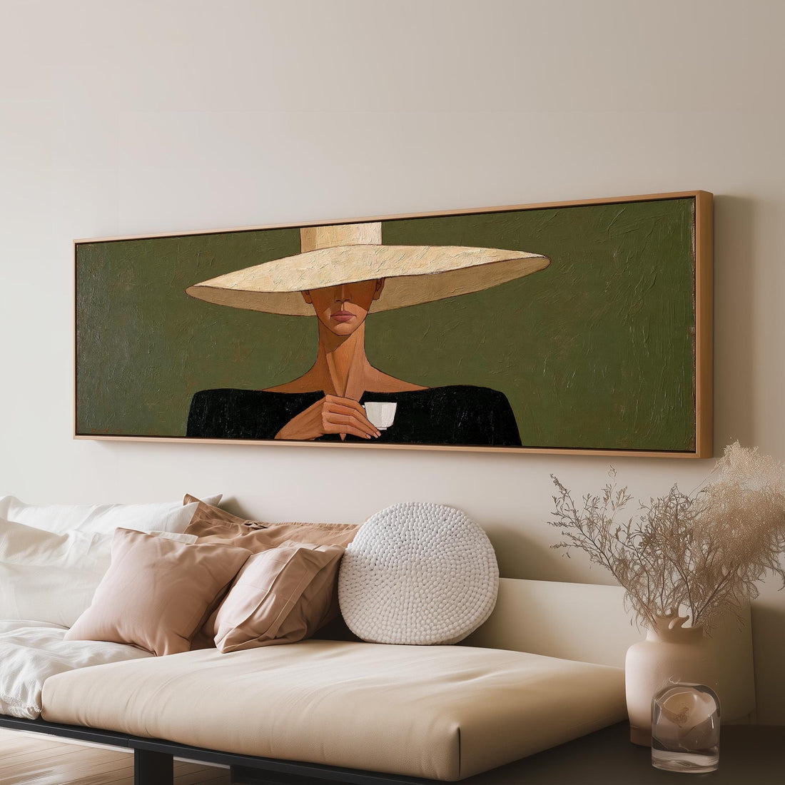 Woman in a wide sun hat holding an espresso long horizontal canvas print above a sofa in a living room