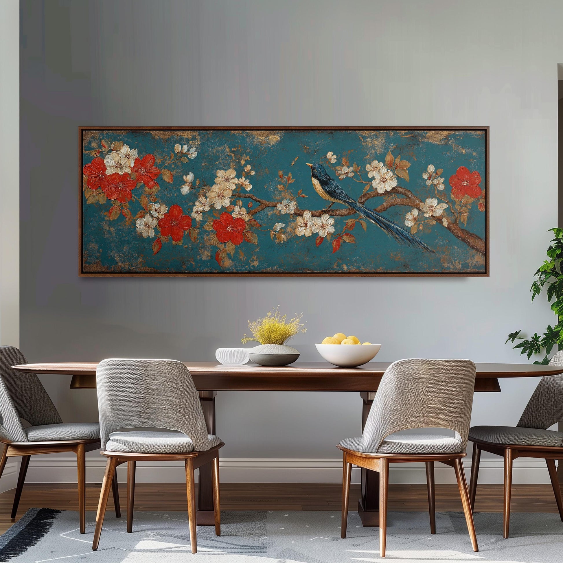 a dining room with a large floral painting hanging on the wall above a wooden table with four chairs. The table is set with a bowl of fruit and a vase of flowers, creating a cozy and inviting atmosphere.