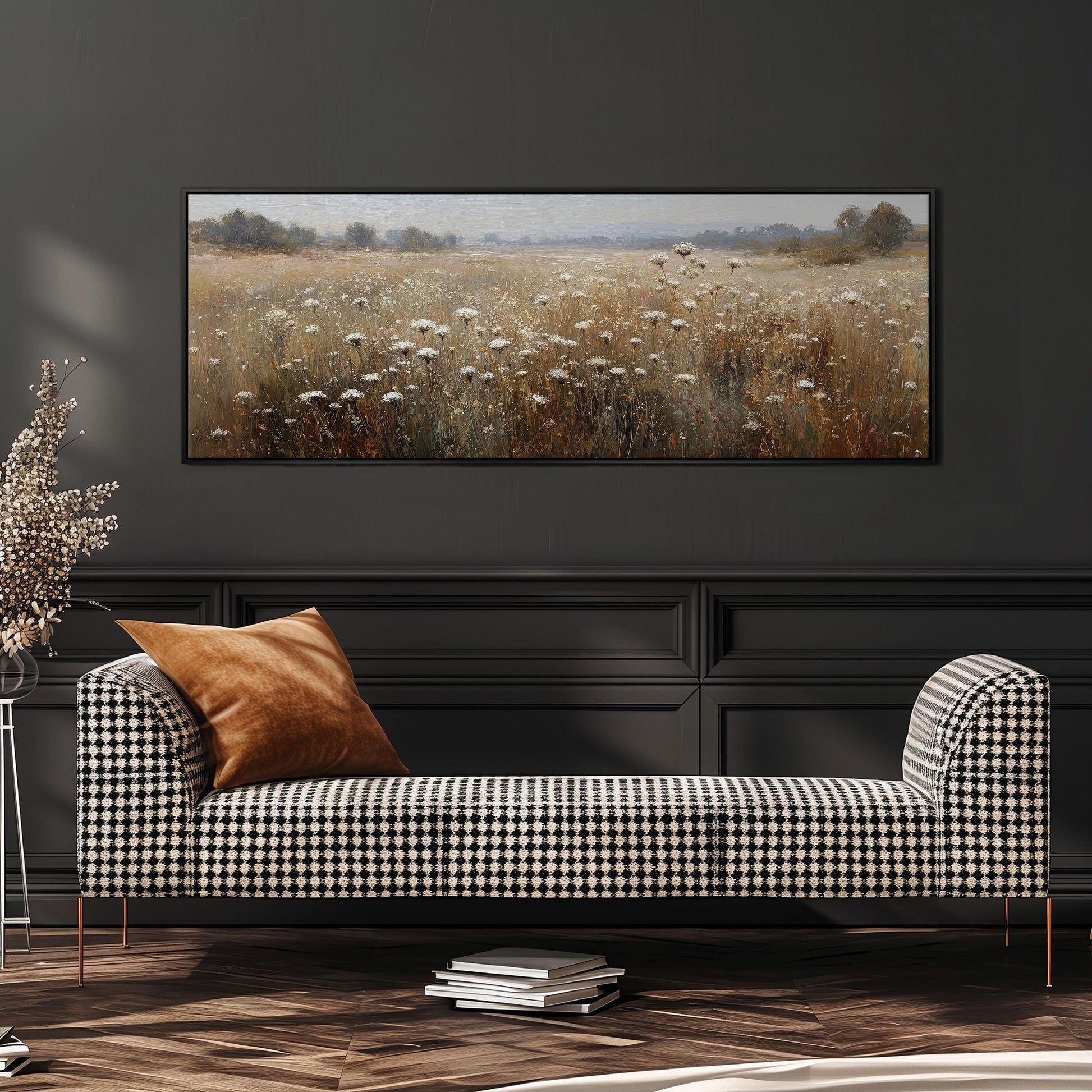 a black and white checkered sofa with a brown throw pillow, set against a dark wall with a large painting of a field of flowers hanging above it.