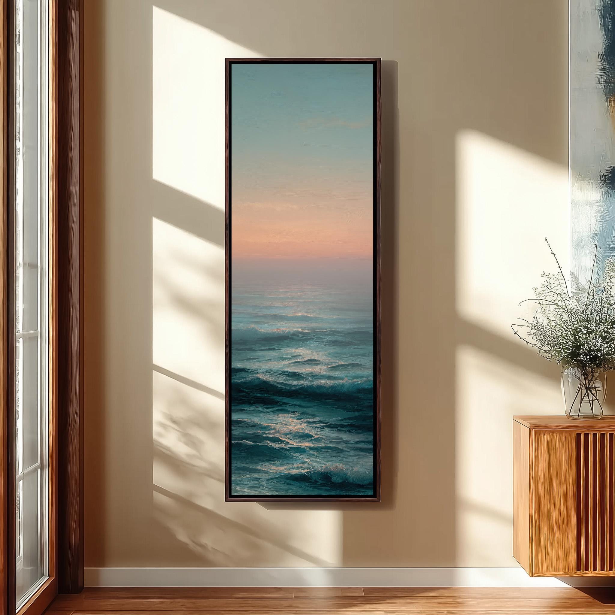 a large, framed painting of a serene ocean scene hanging on a wall, with a wooden cabinet and a vase of flowers to the right of the painting.