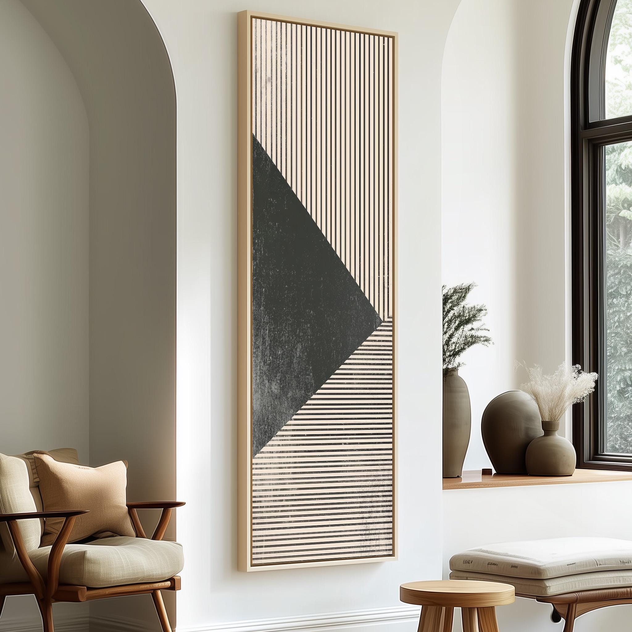 a modern living room with a large abstract painting on the wall, a wooden chair, a small table, and a window with a plant on the sill.