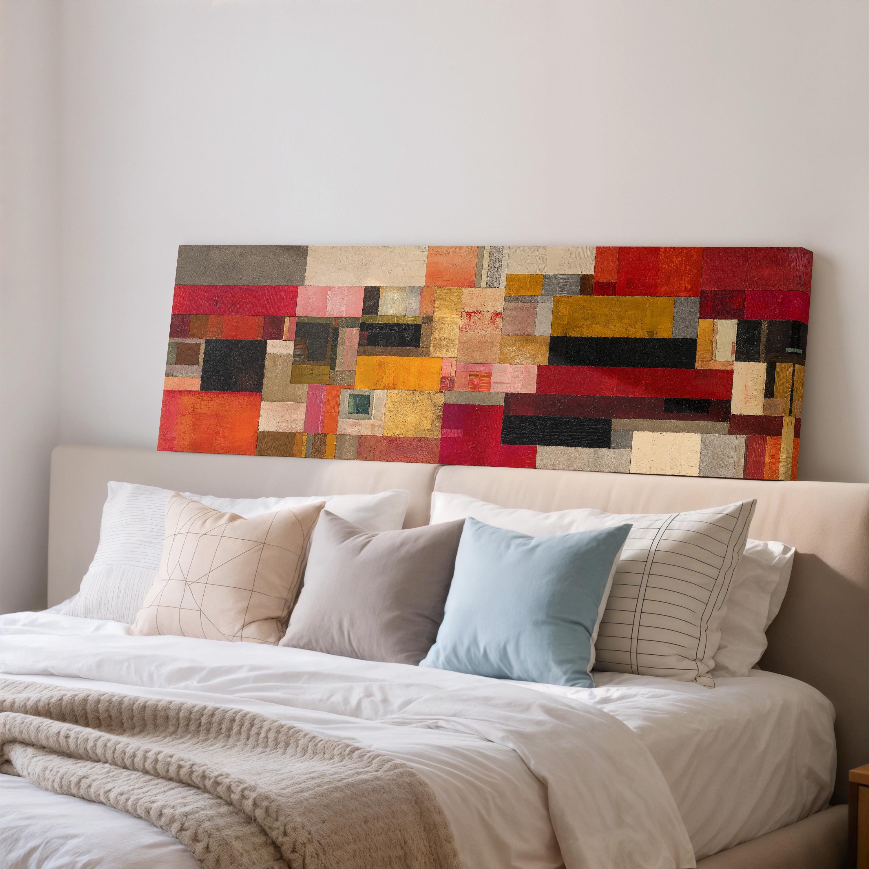 a large, colorful abstract painting hanging above a bed with white pillows and a gray blanket.
