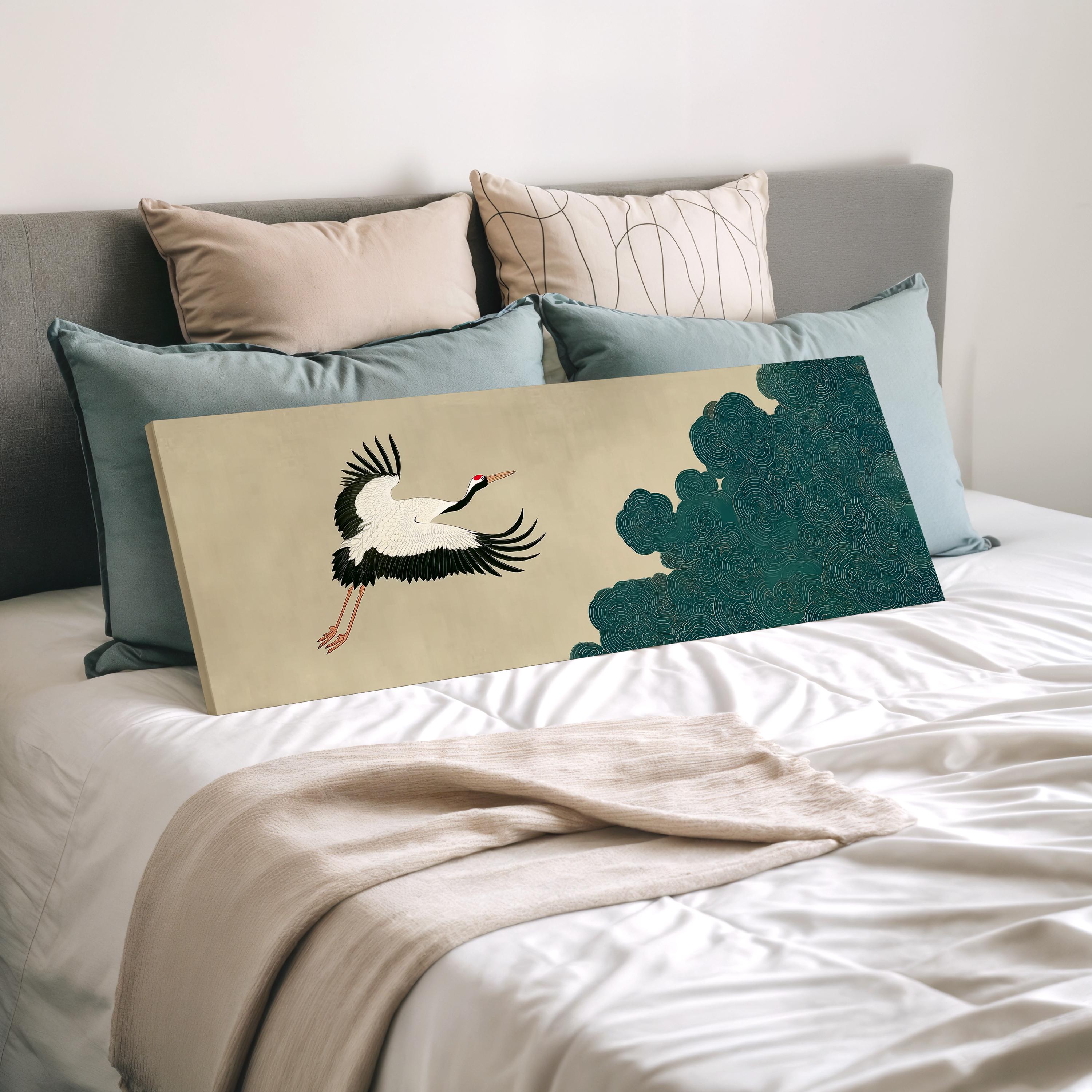 a large bed with a white comforter and a painting of a crane on it. The bed is surrounded by various pillows and a blanket.