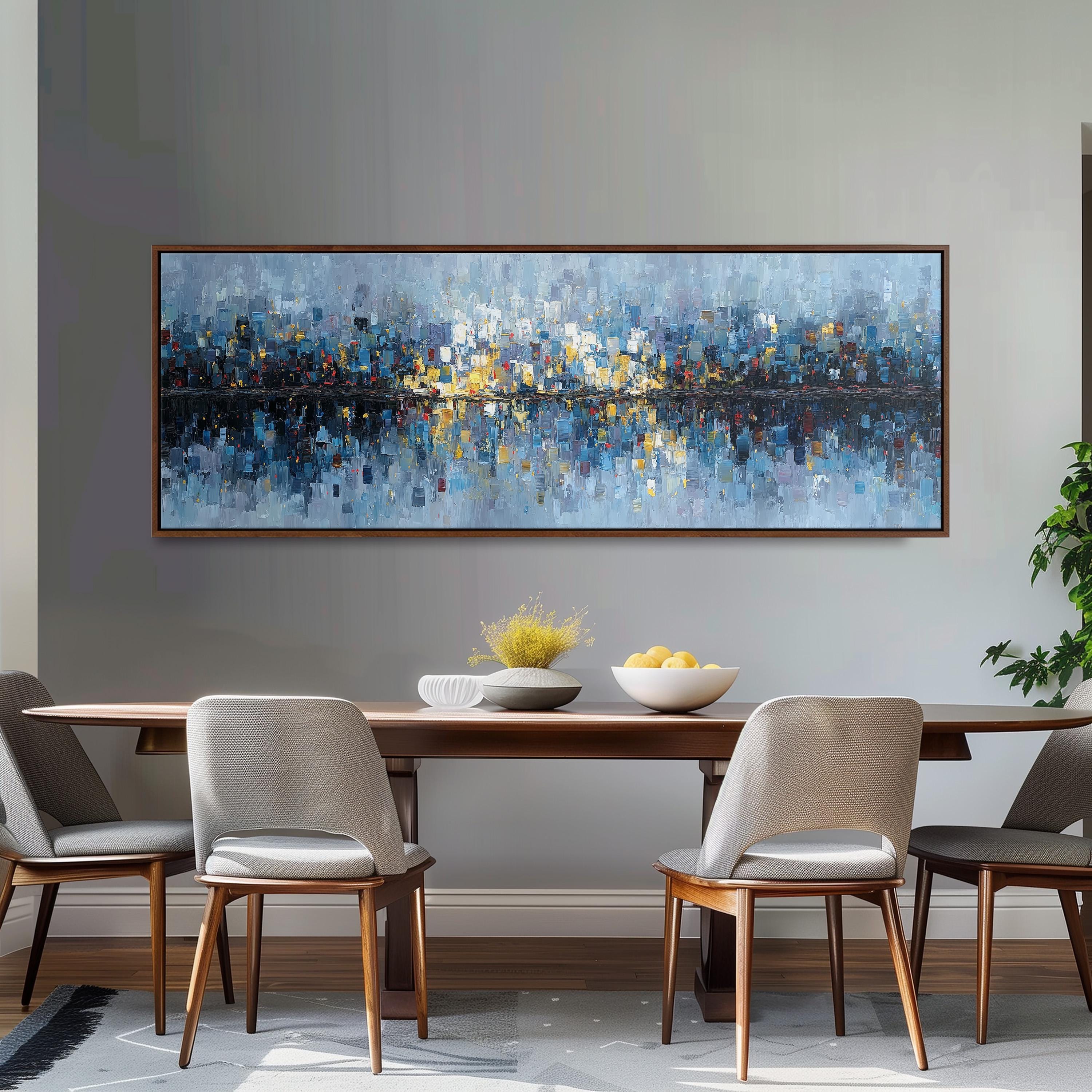 a large, colorful painting of a cityscape hanging on a wall above a wooden dining table with four chairs. The table is set with a bowl of fruit and a vase of flowers, creating a cozy and inviting atmosphere.