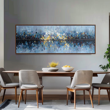 a large, colorful painting of a cityscape hanging on a wall above a wooden dining table with four chairs. The table is set with a bowl of fruit and a vase of flowers, creating a cozy and inviting atmosphere.