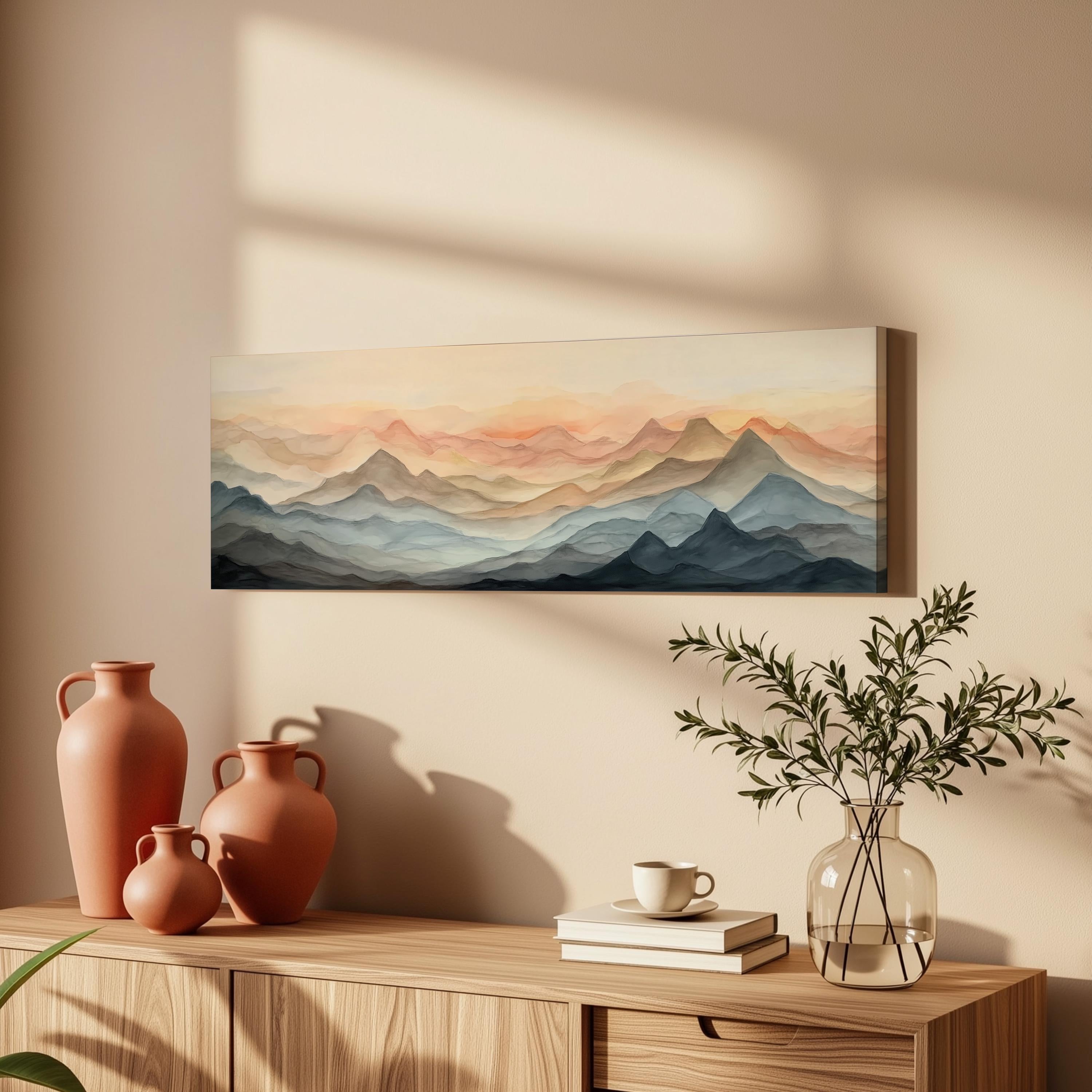 a wooden cabinet with a painting of mountains hanging on the wall above it, along with three orange vases and a glass vase with greenery on the cabinet.