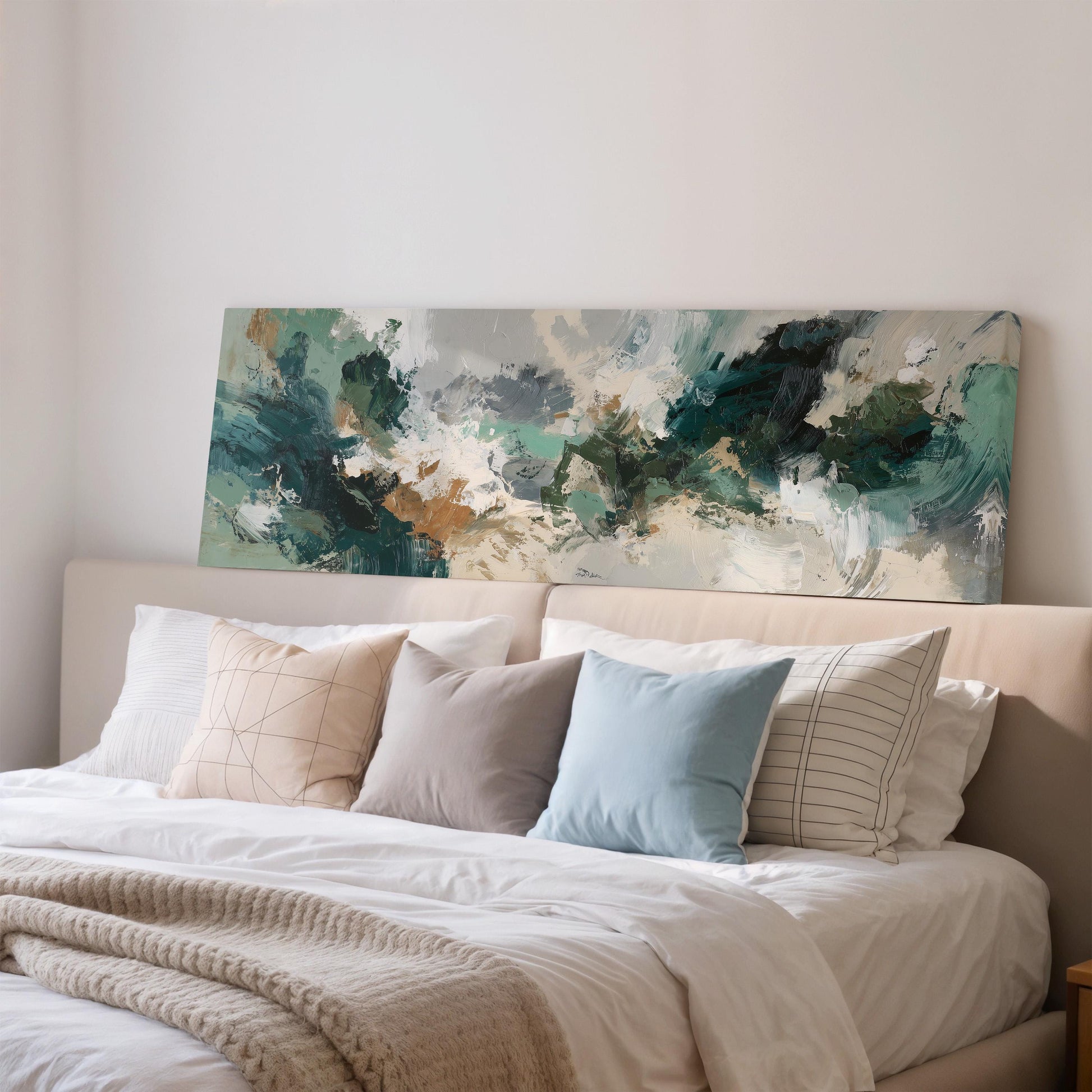 a large abstract painting hanging on a wall above a bed with white bedding and various pillows.