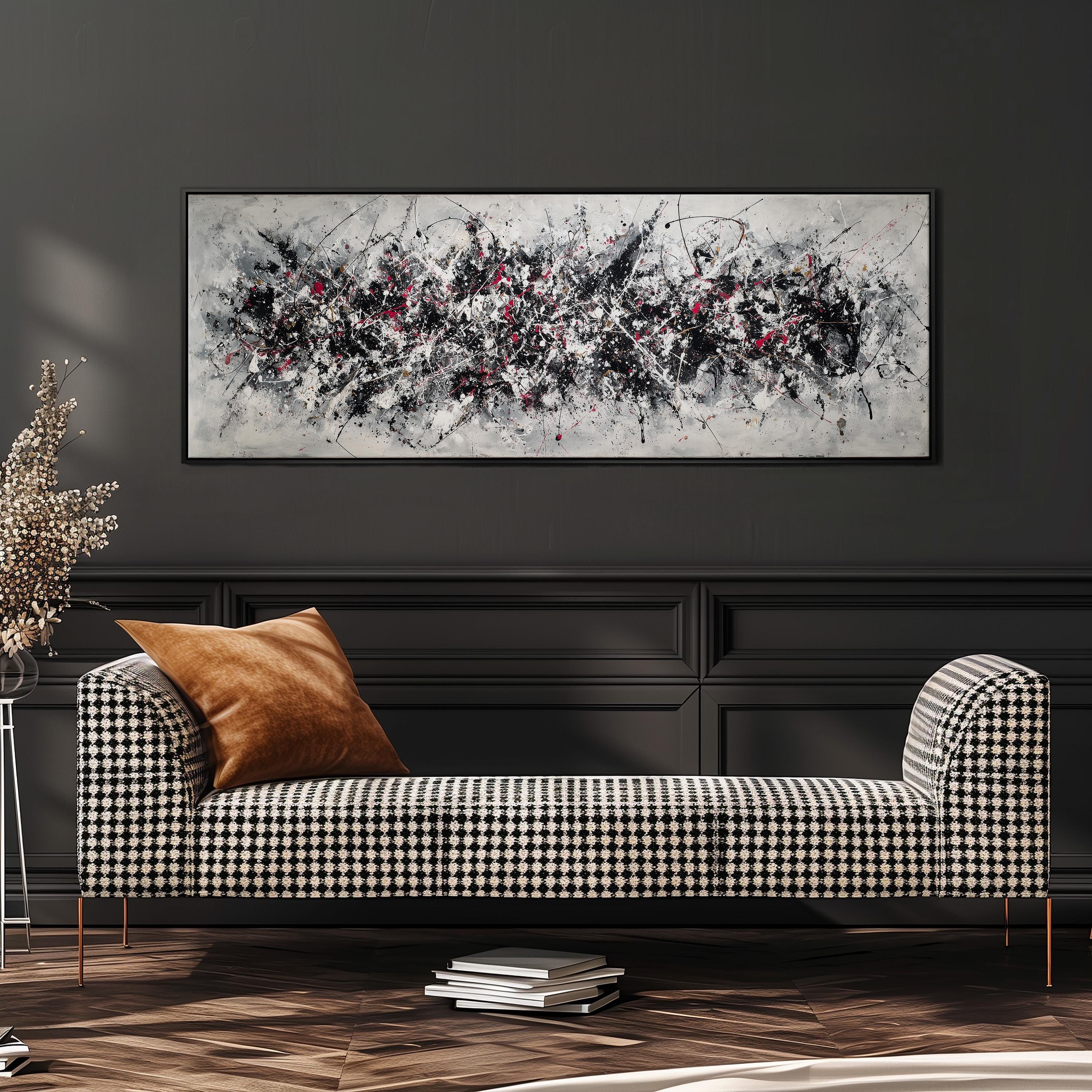 a modern living room with a black and white checkered sofa, a large abstract painting on the wall, and a stack of books on the floor.