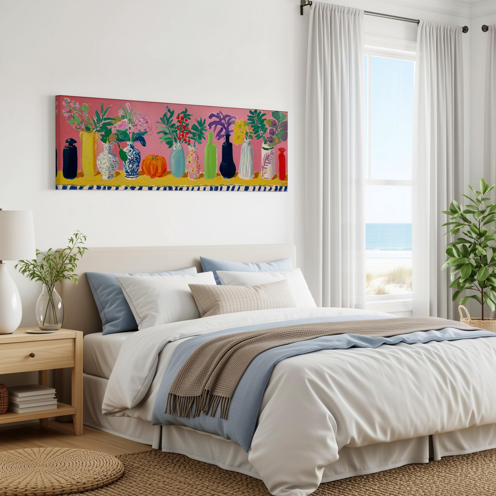 a bedroom with a large bed, a nightstand, and a painting of colorful vases on the wall. The room has a beach view through a window, and there are potted plants and a rug on the floor.