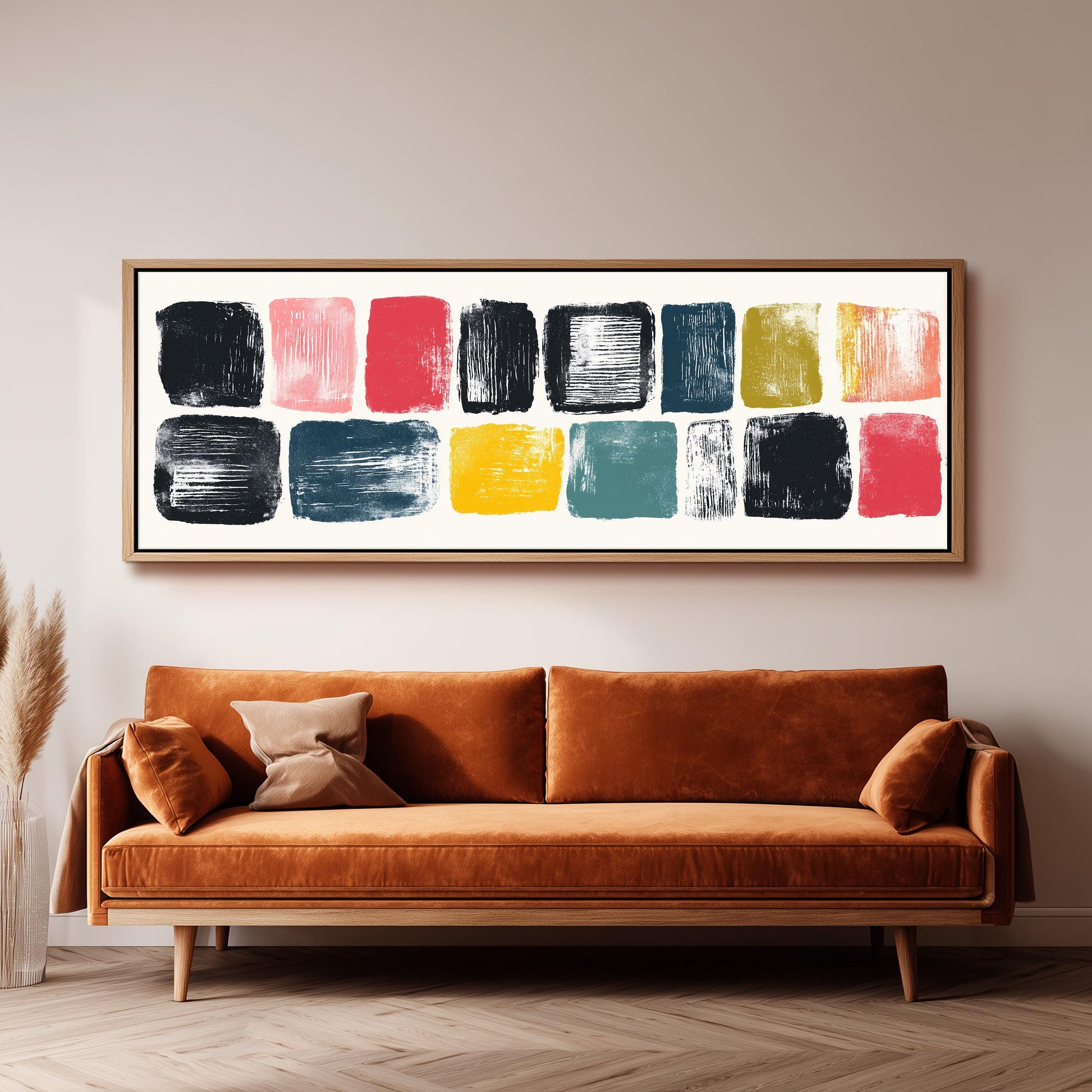 a large abstract painting hanging on a wall above a brown sofa with two pillows.