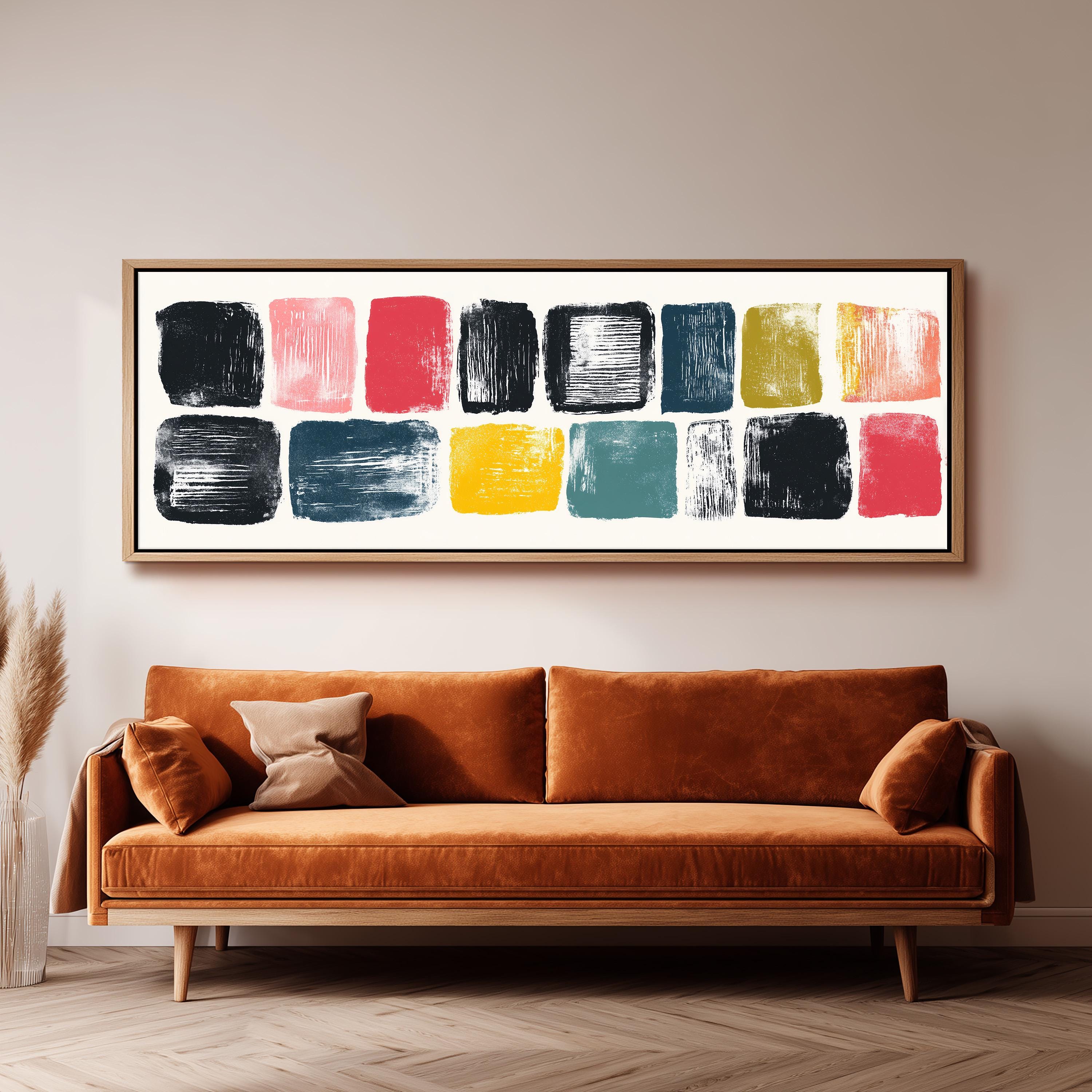 a large abstract painting hanging on a wall above a brown sofa with two pillows.