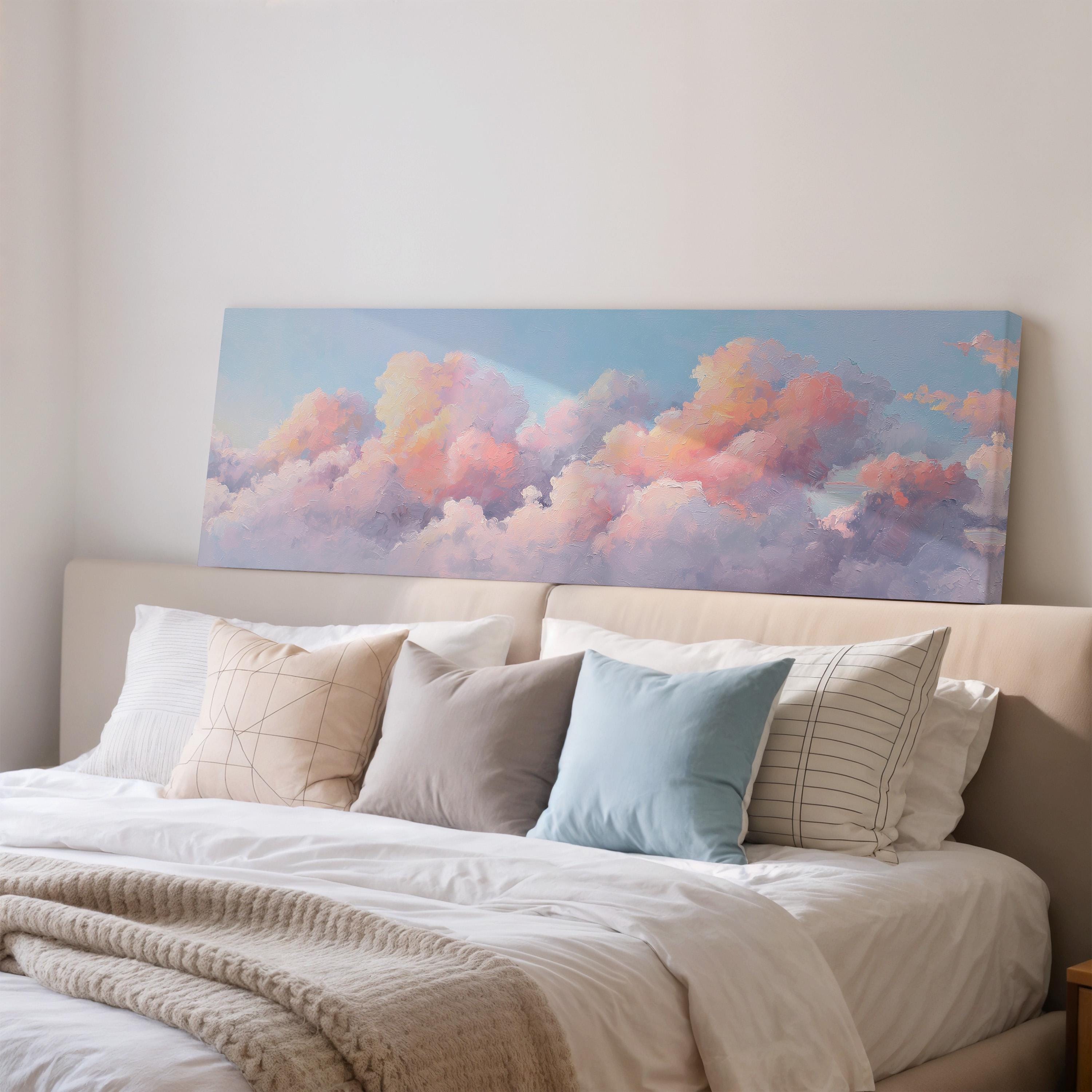 a large bed with a white comforter and pillows, and a large canvas print of a cloud-filled sky above it.