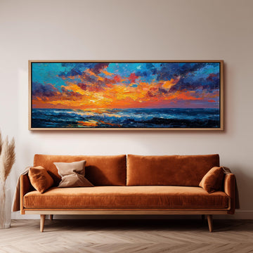 a large, vibrant painting of a sunset over the ocean hanging on a wall above a brown sofa.